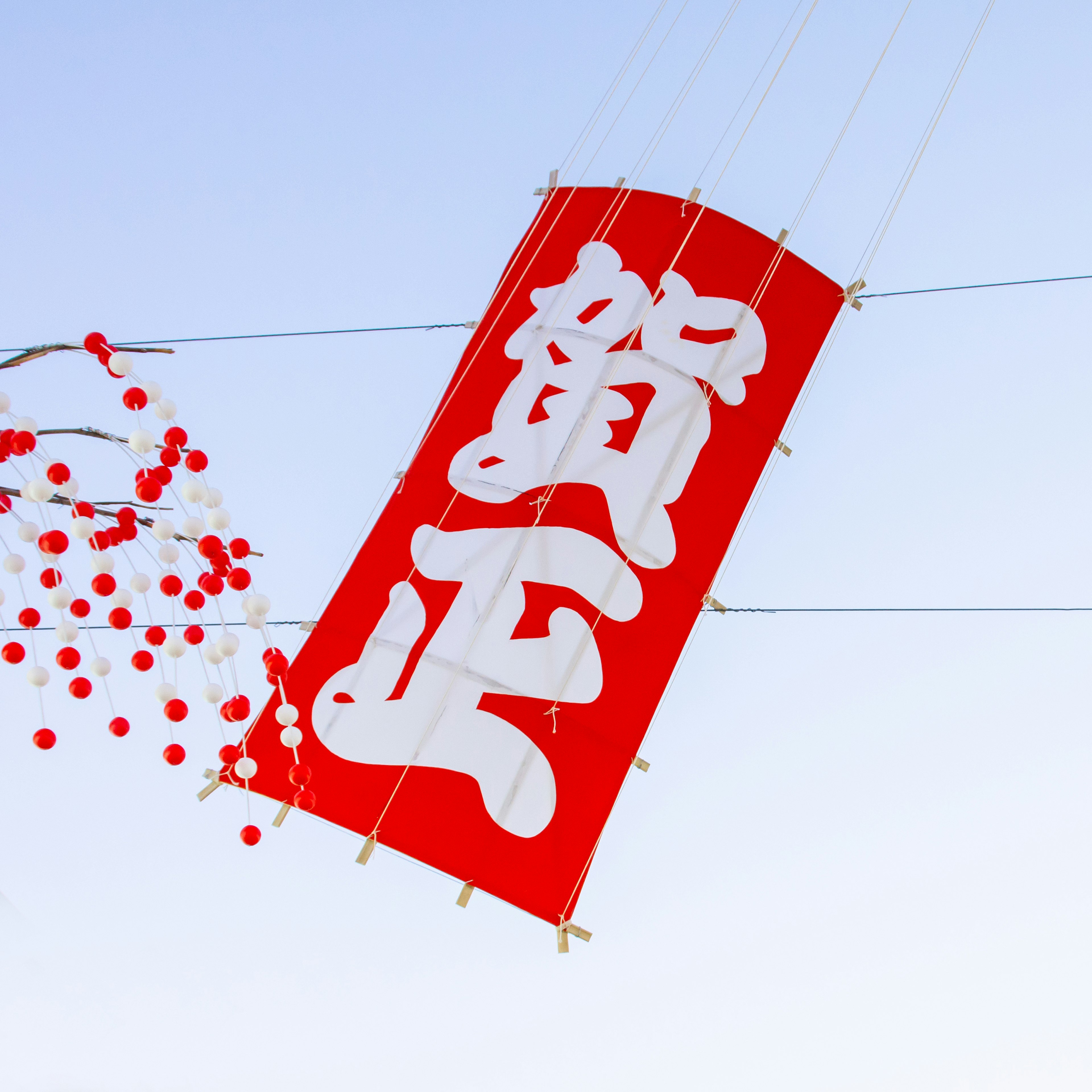 Rotes Banner mit weißen Zeichen '賀正'