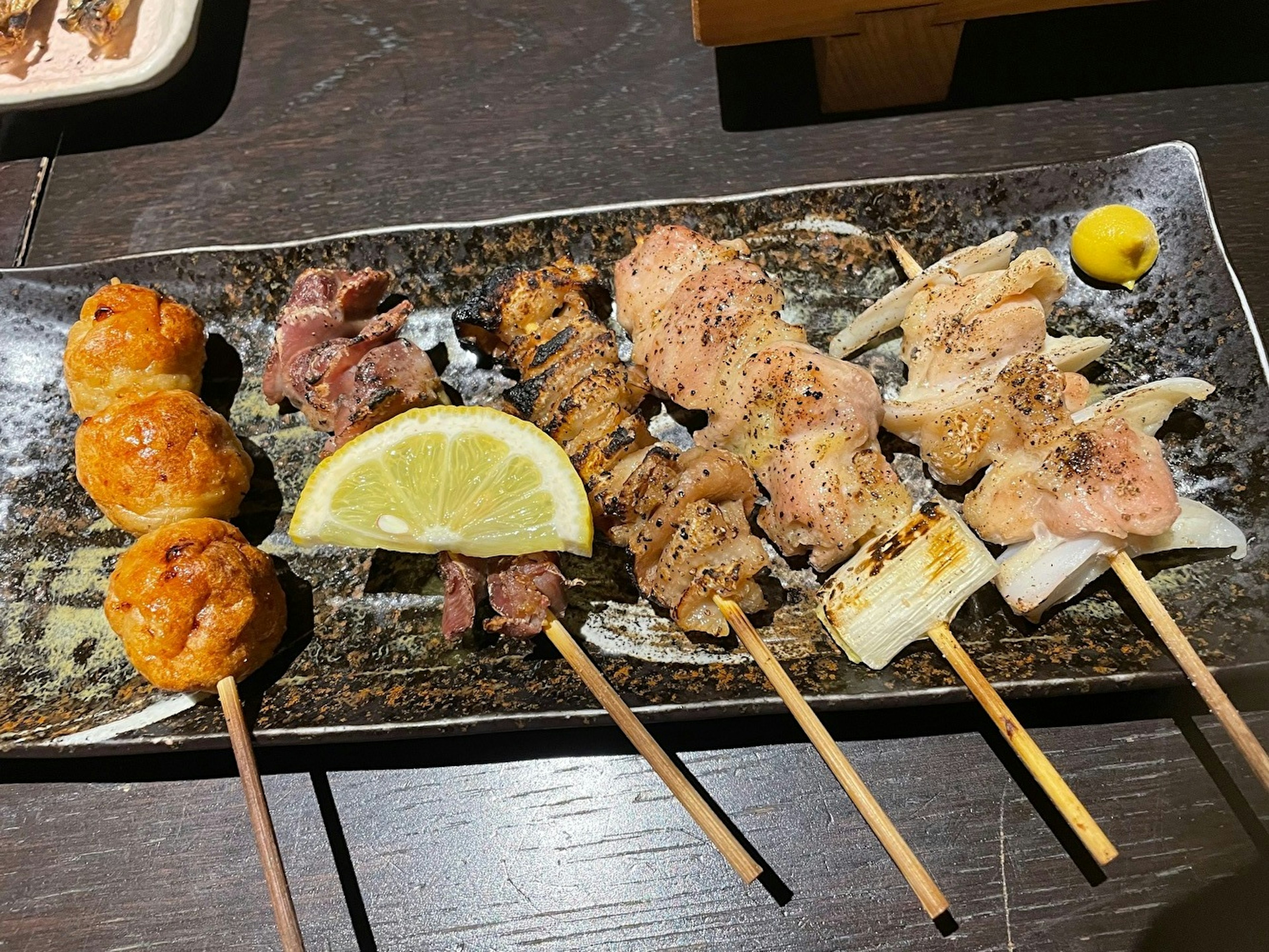 Platter of assorted yakitori skewers with lemon slice