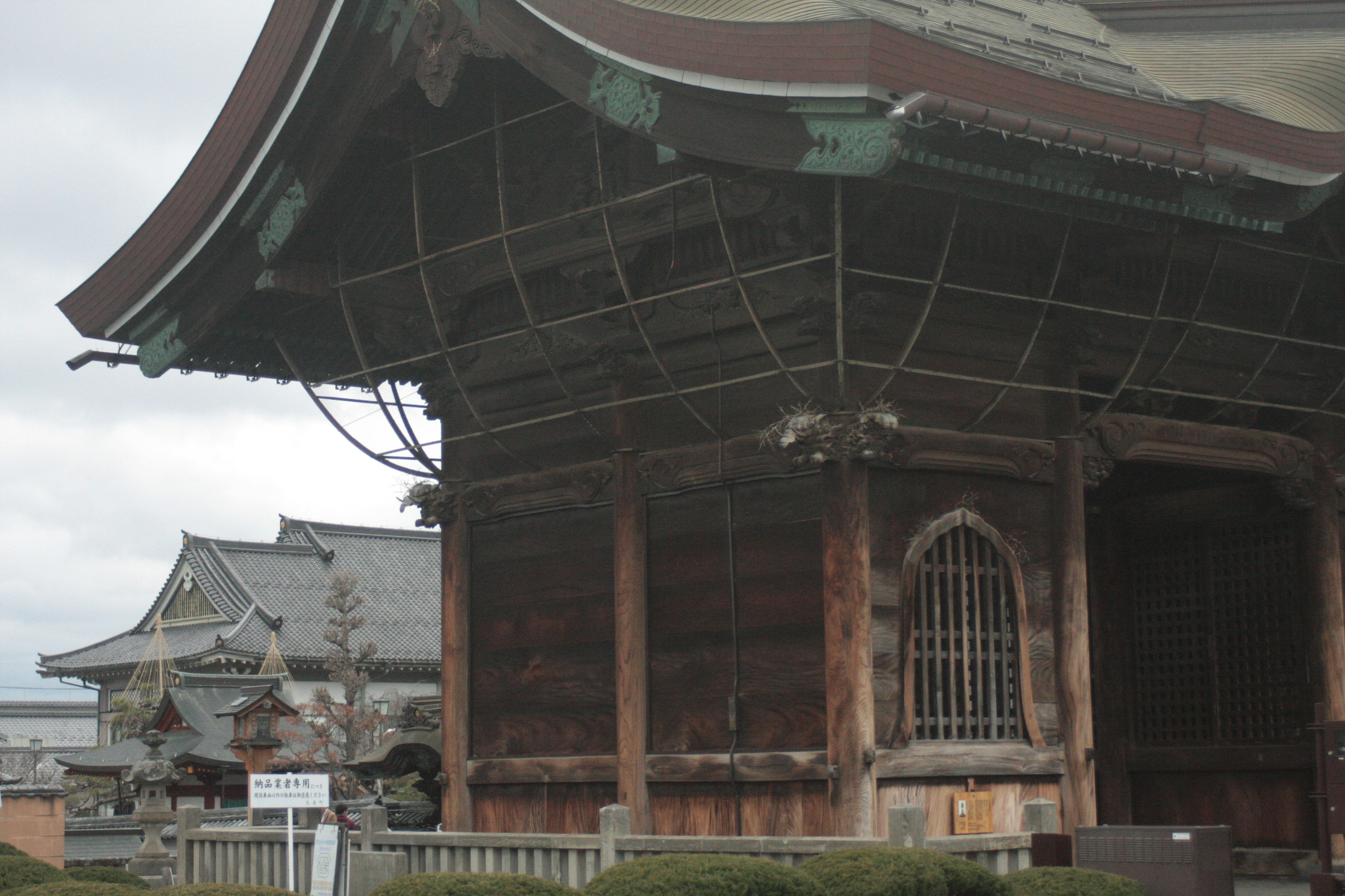 An ancient temple building with a large roof showcasing wooden structure and intricate details