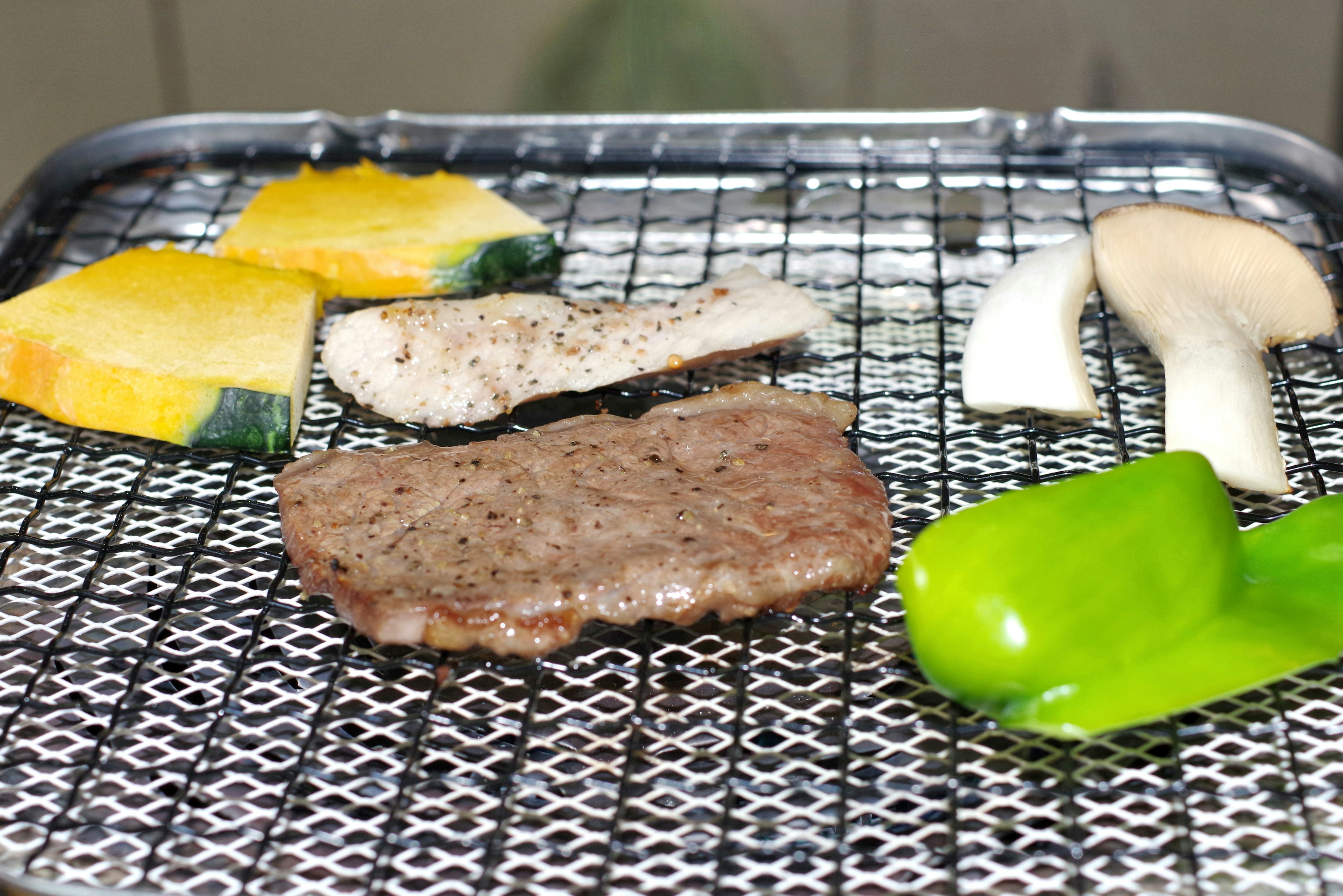 Grilled meat and vegetables arranged on a grill