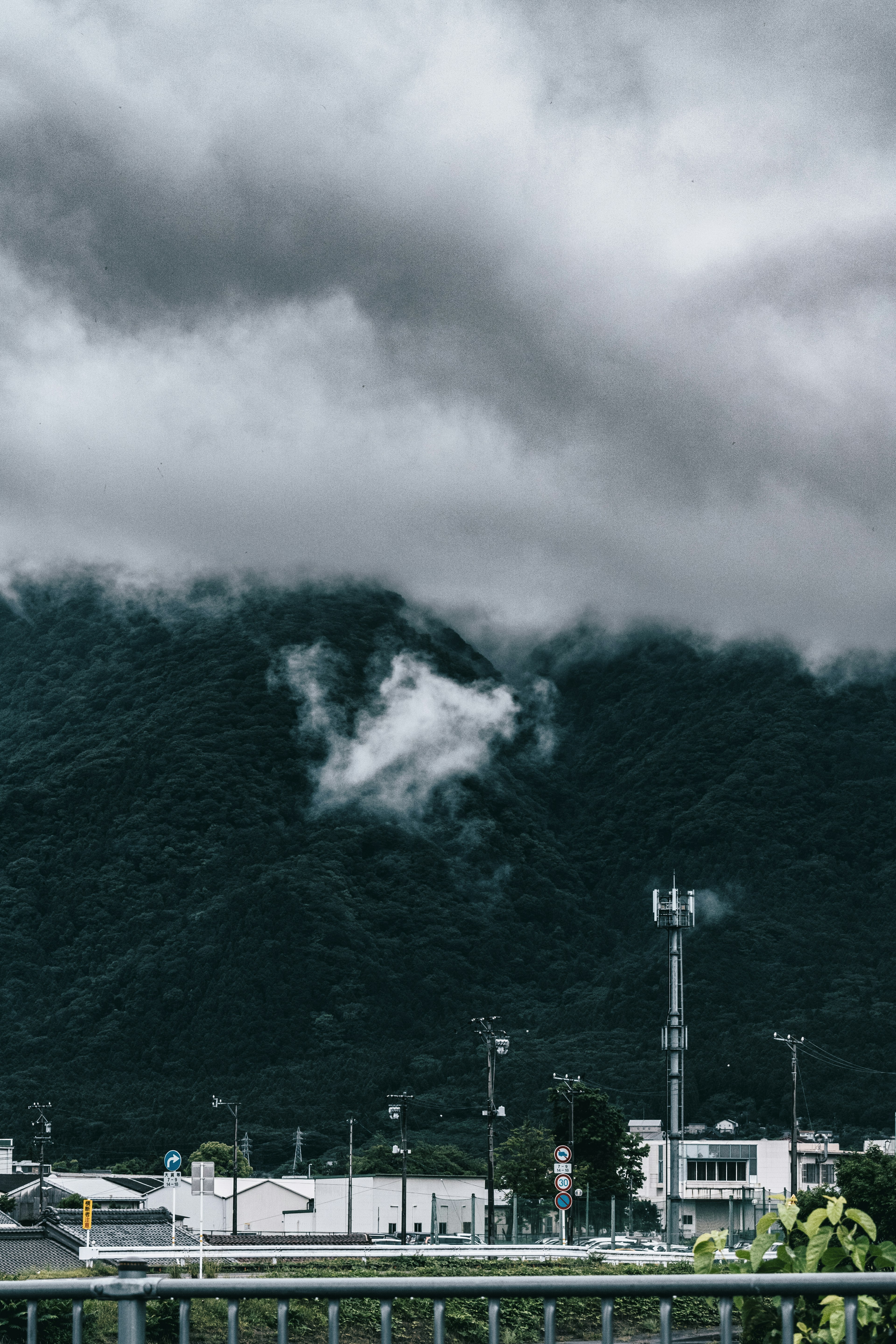 山と雲の風景にある建物と通信塔