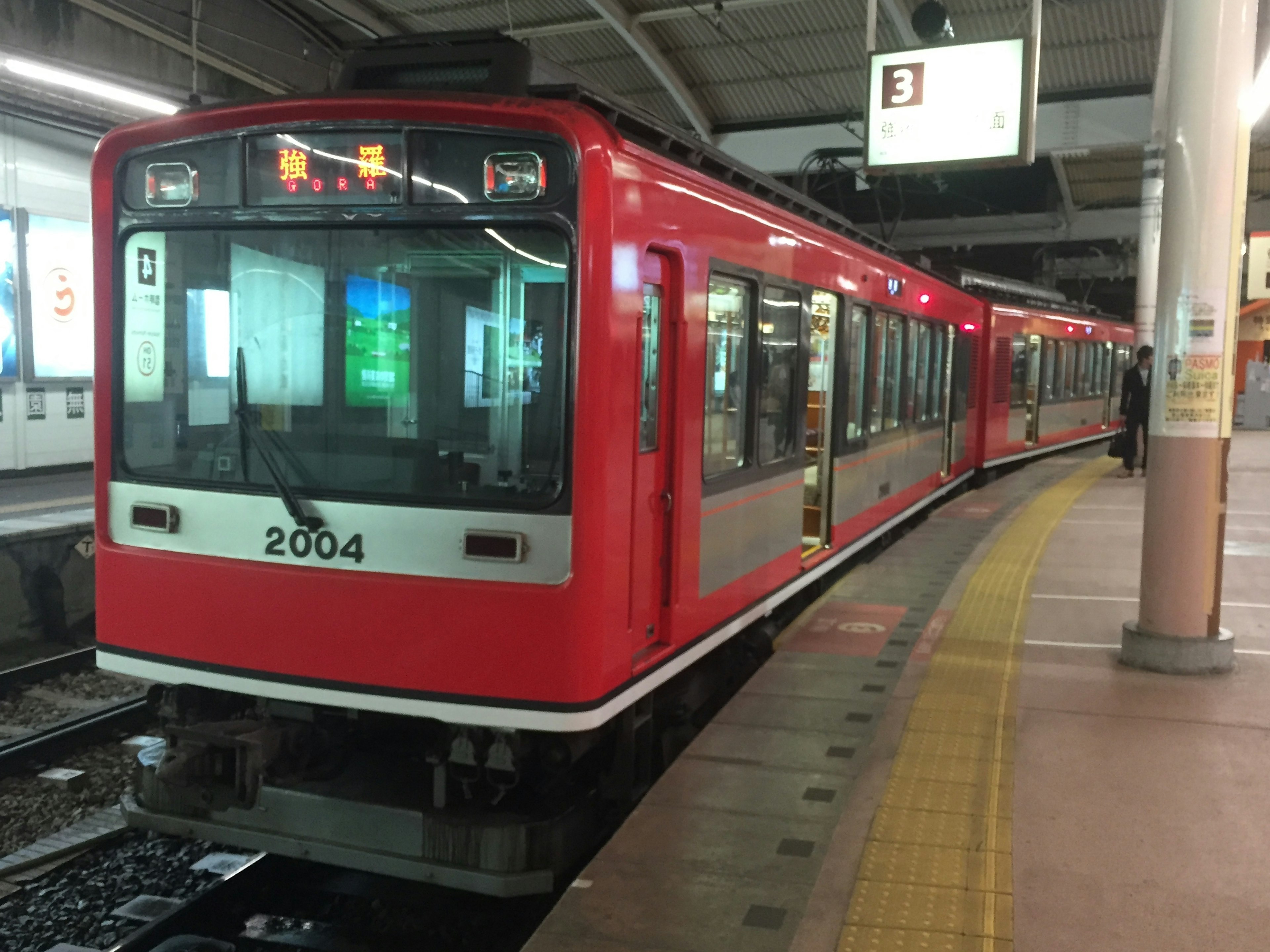 赤い電車が駅のプラットフォームに停車している