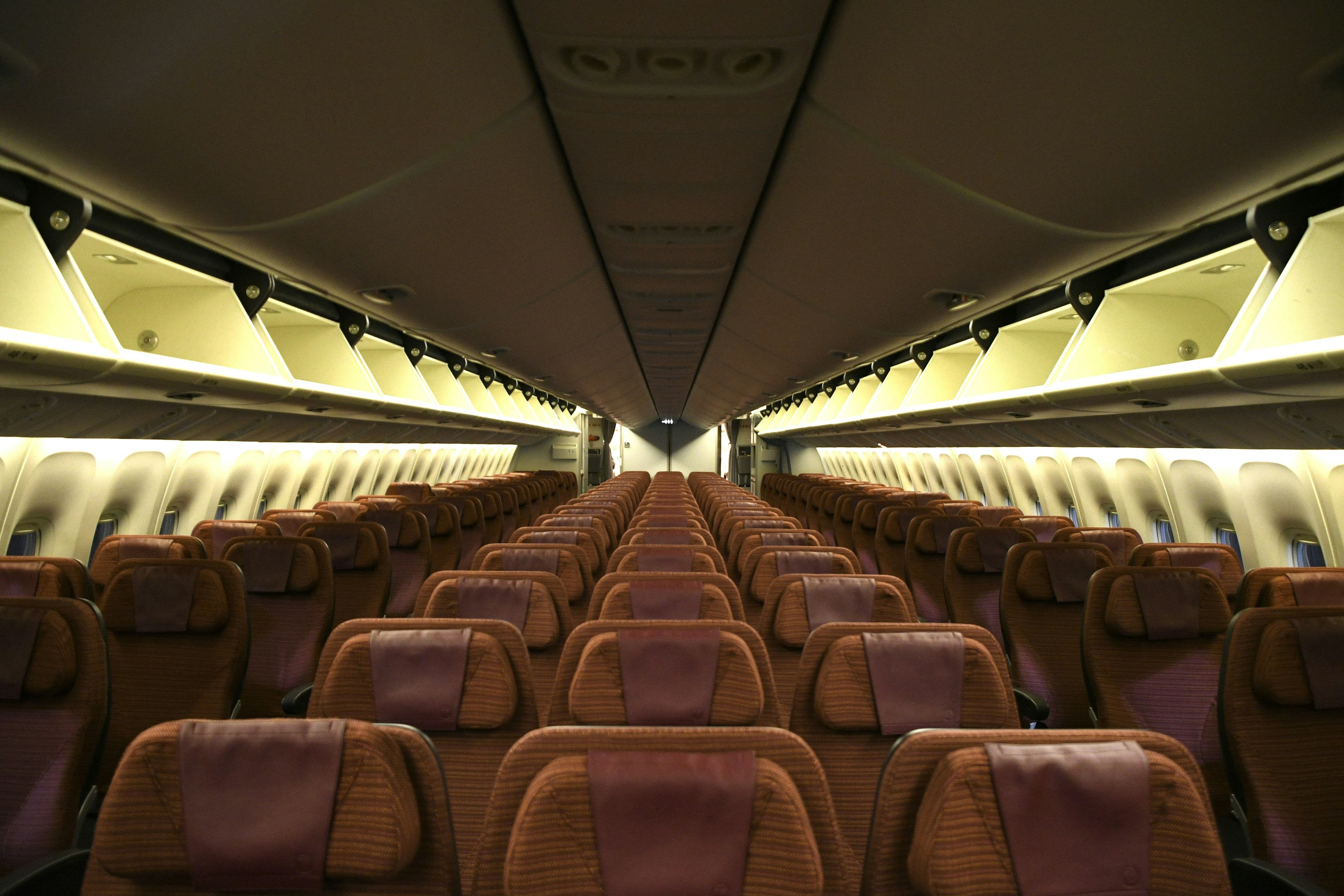 Interior of an airplane showing a long aisle and rows of seats