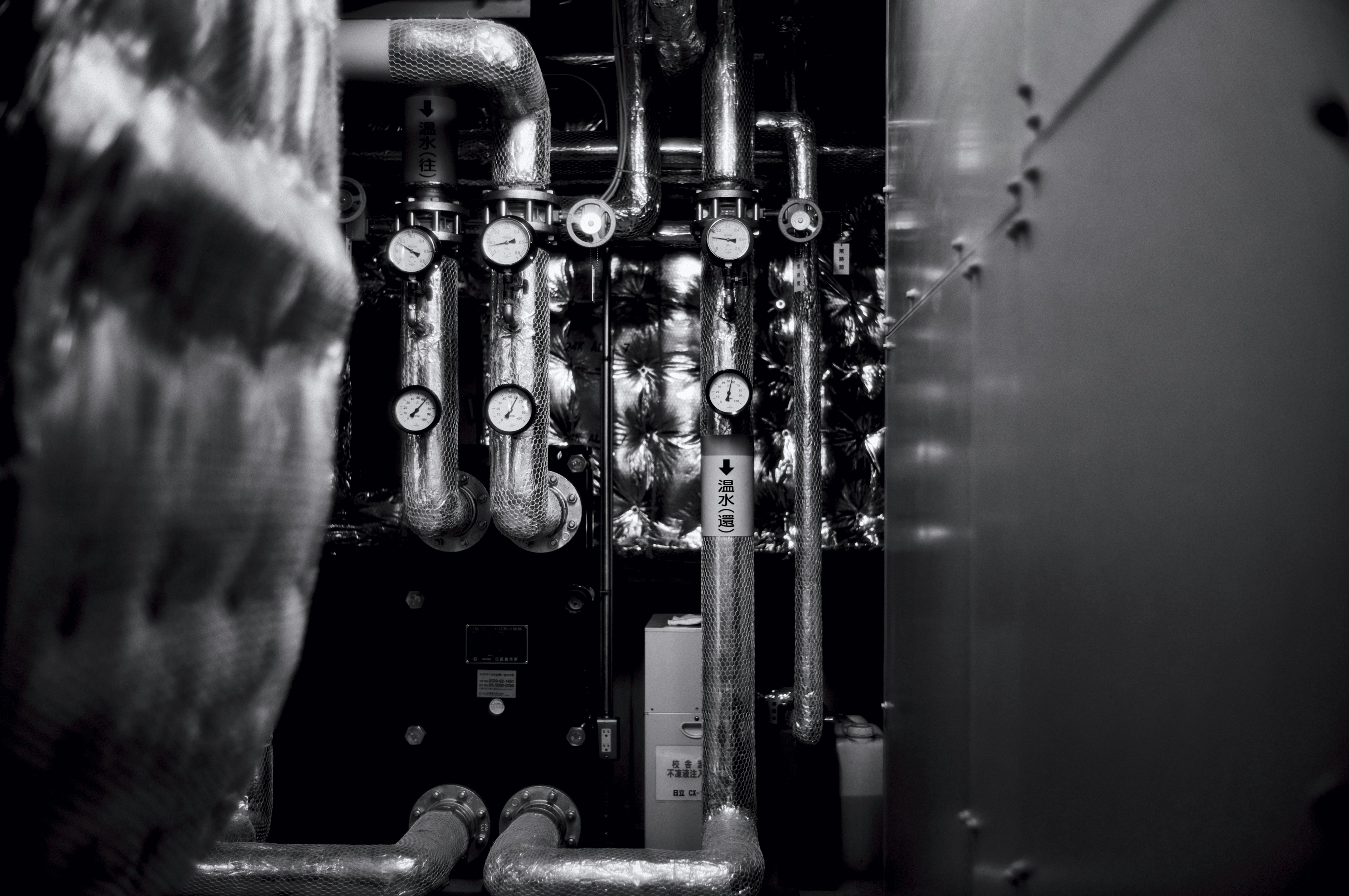 Interior de una sala de máquinas industrial con tuberías y manómetros