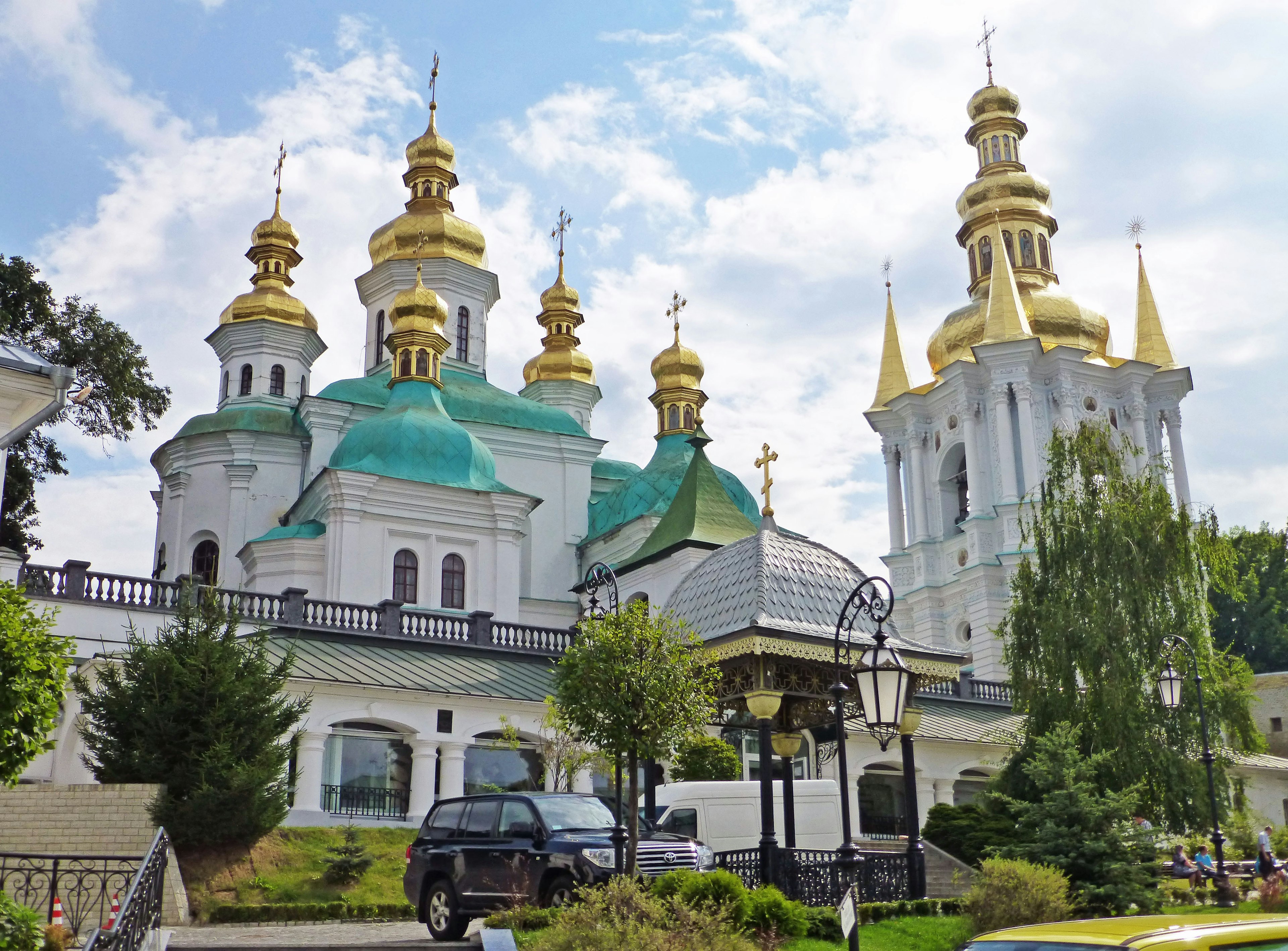 Stunning church building with golden domes featuring green roofs and white walls