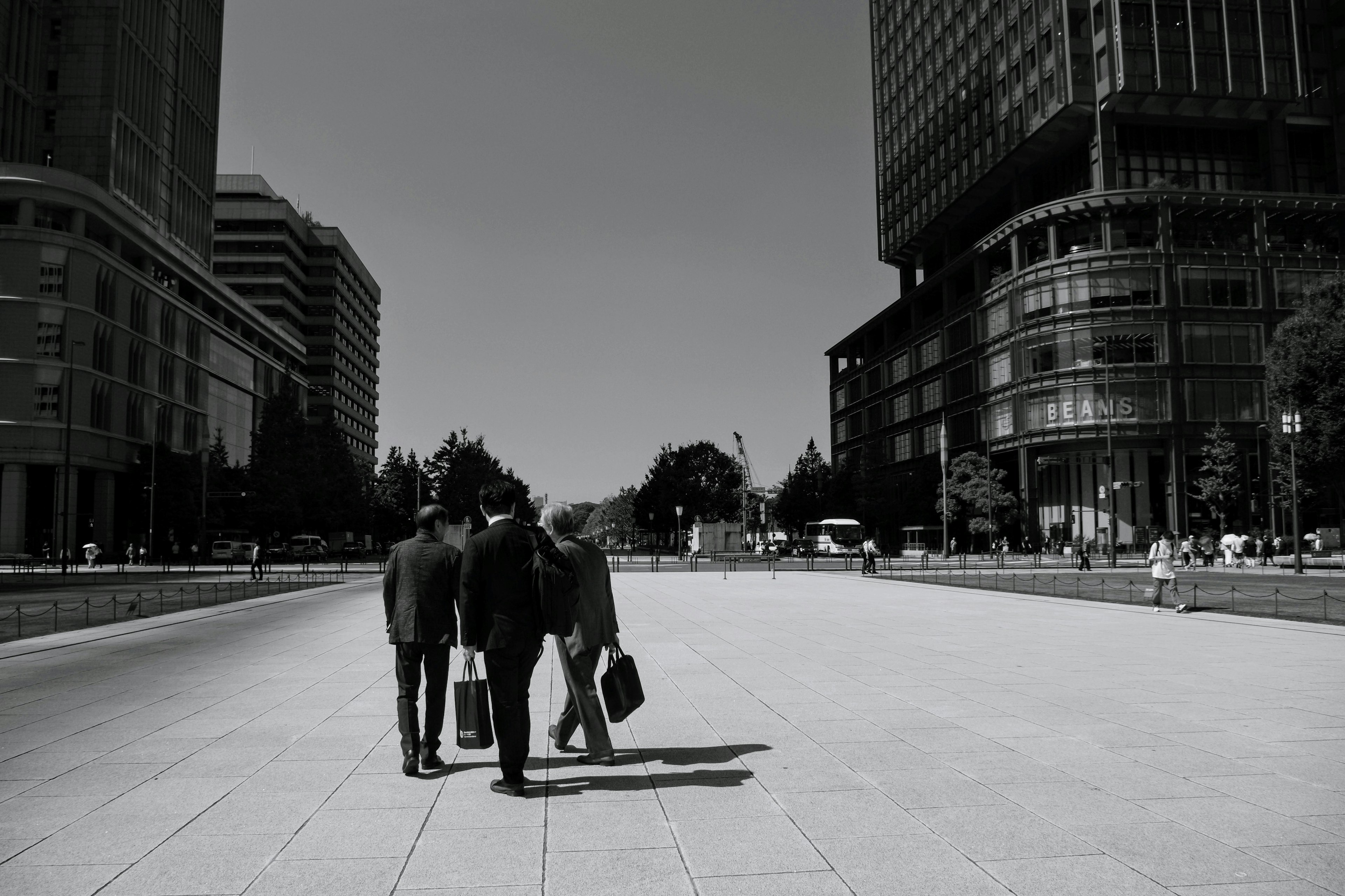 Hommes d'affaires en costumes marchant dans un paysage urbain en noir et blanc