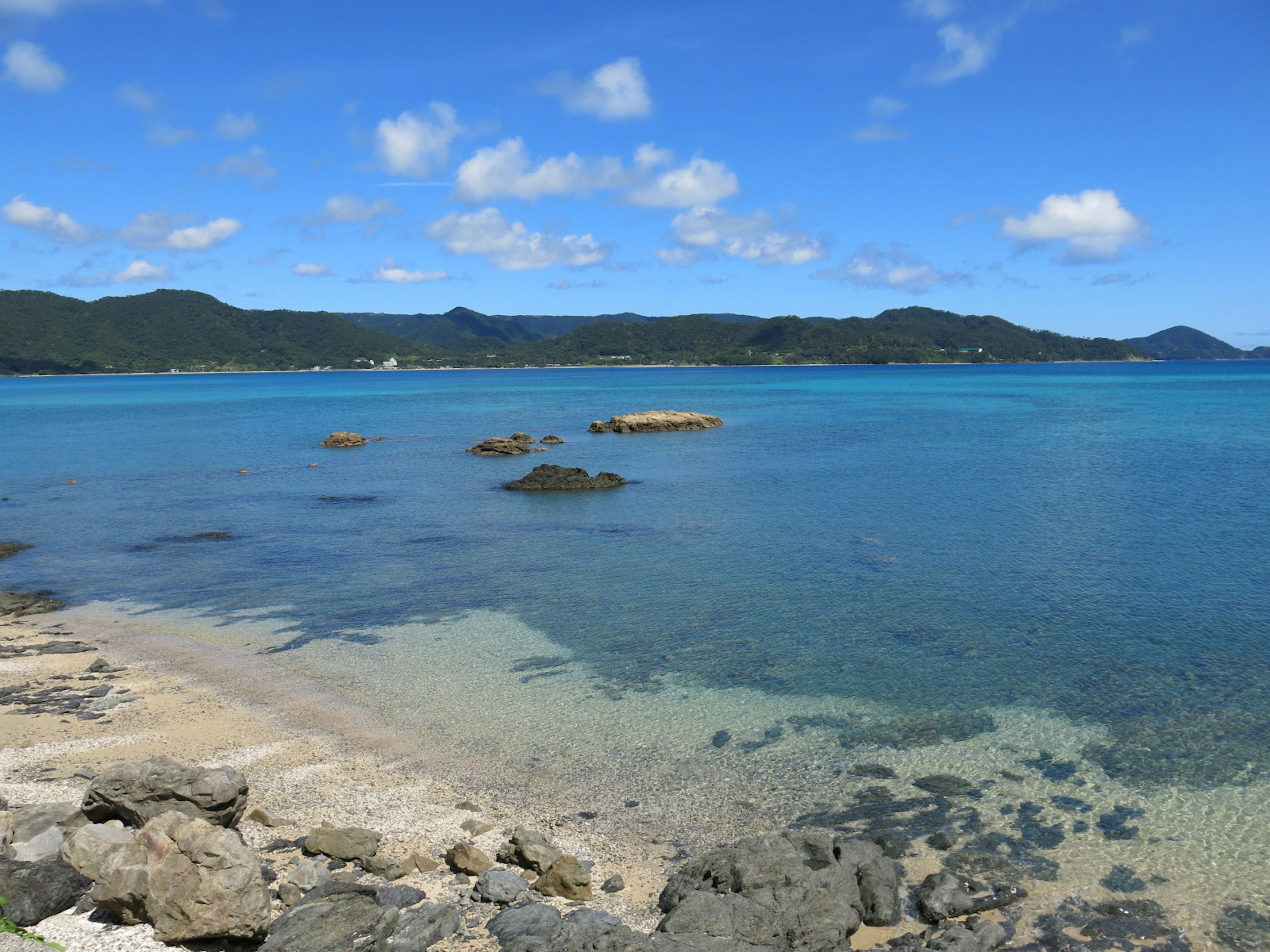 ทะเลสีน้ำเงินใสกับทิวทัศน์ชายหาดทรายสงบ