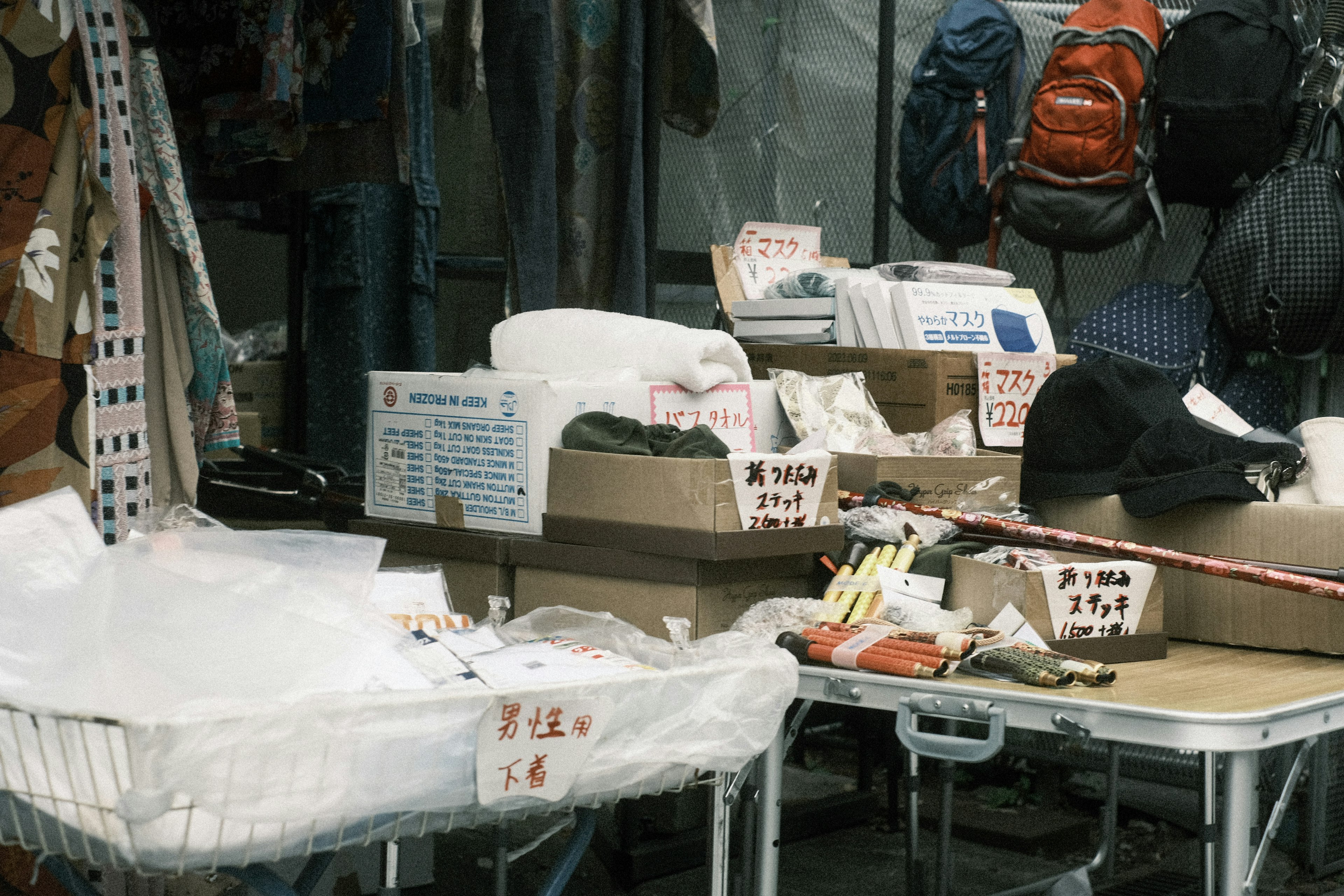 Une table de marché encombrée affichant divers articles et des cartons