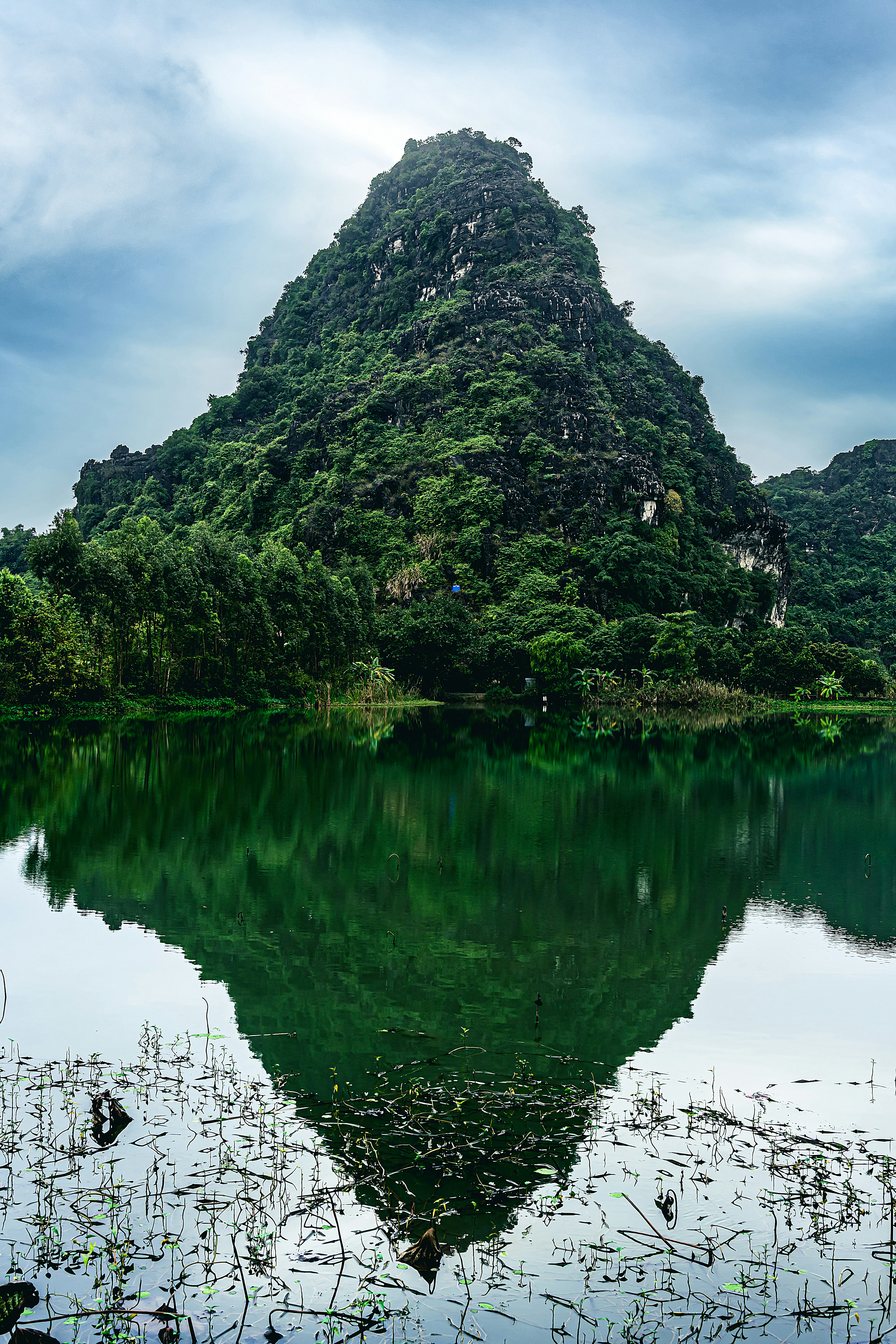 寧靜湖面上倒映的綠色山峰的美麗景色