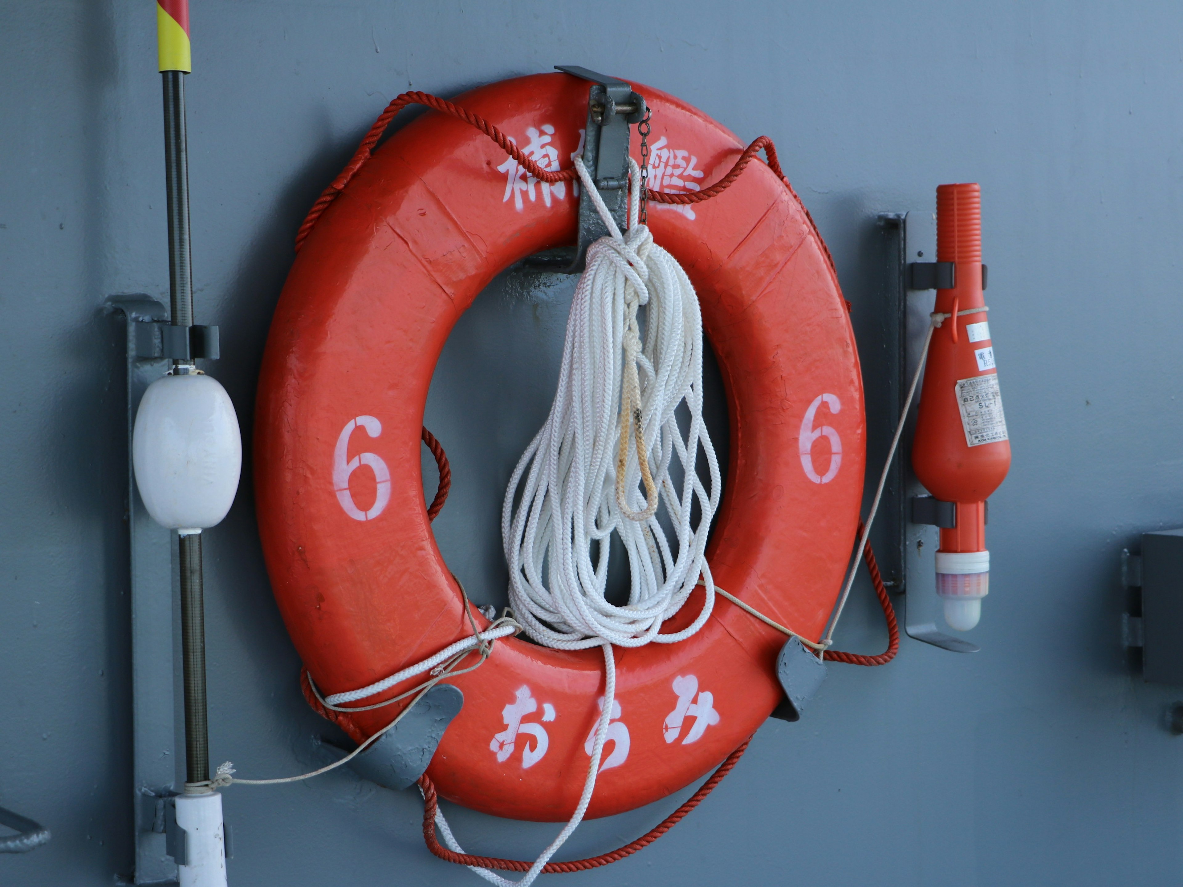 Red life buoy with rope attached to a wall