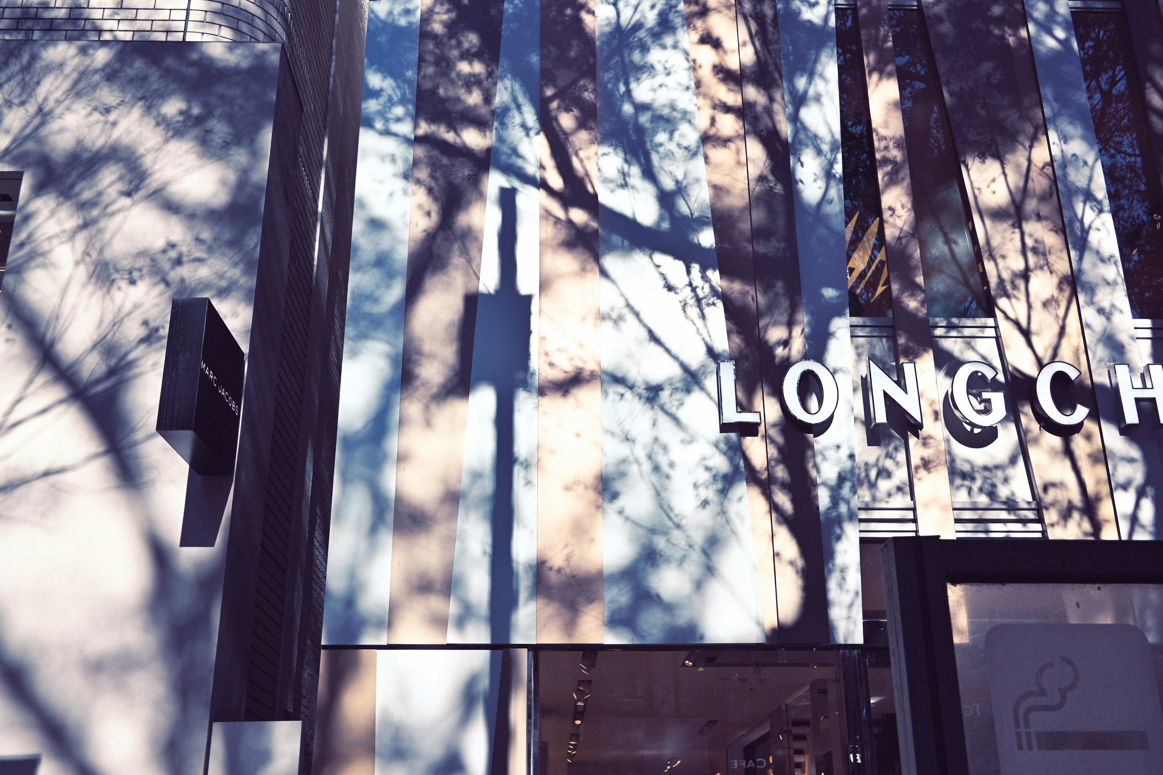 Facade of Longchamp store with shadows reflecting on the wall