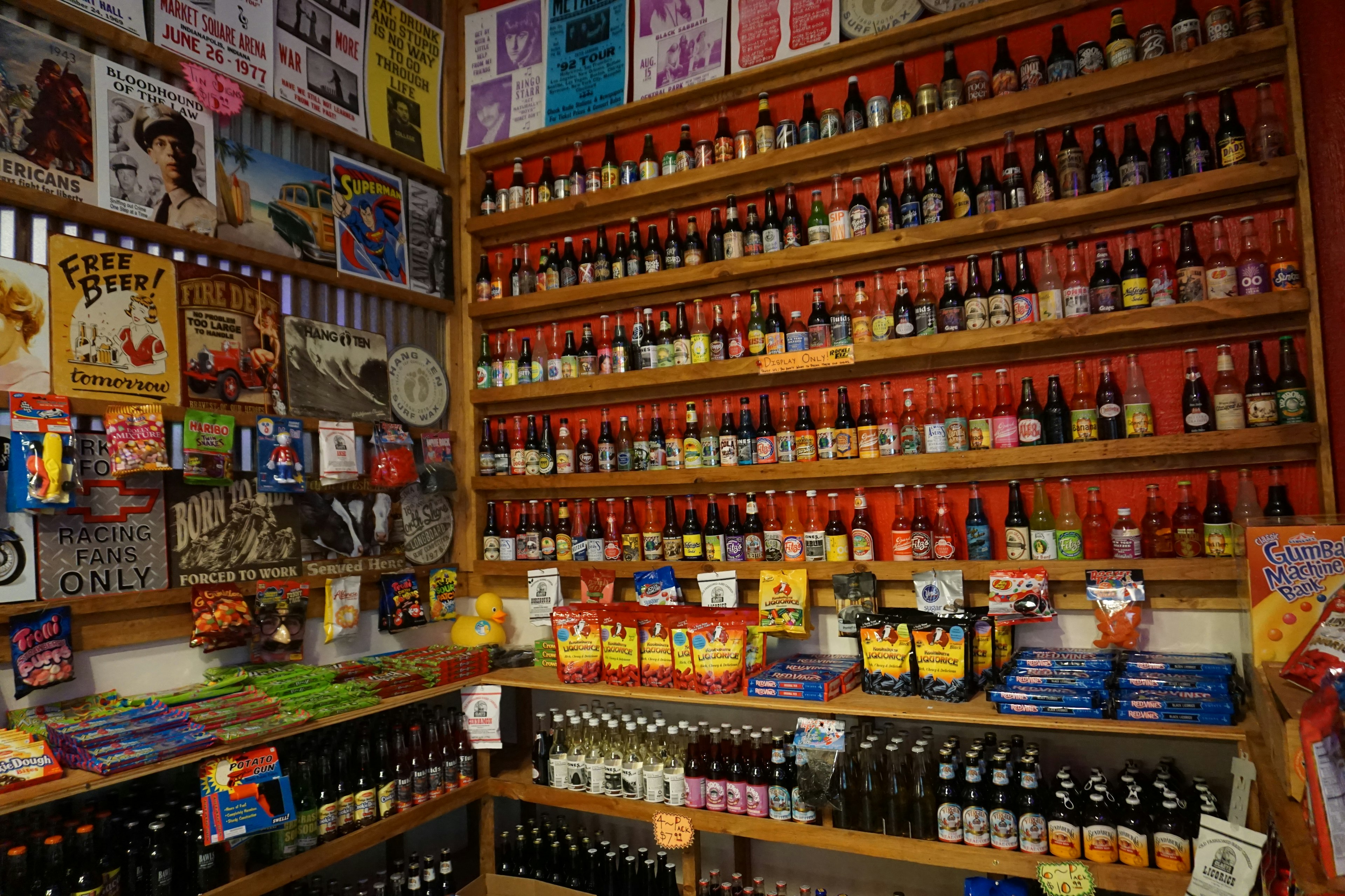 Interior de una tienda llena de bebidas coloridas en estantes