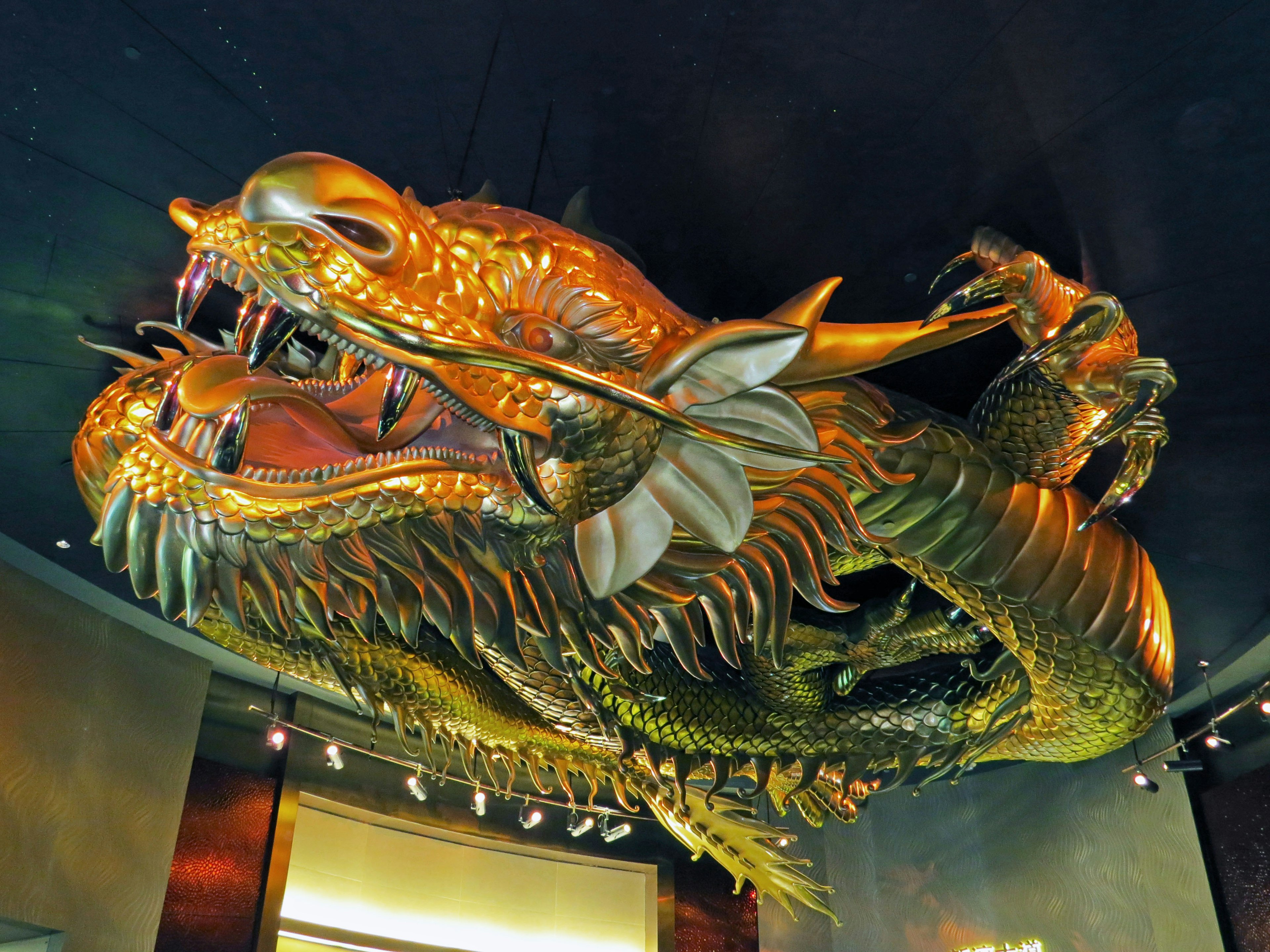 A stunning golden dragon sculpture hanging from the ceiling