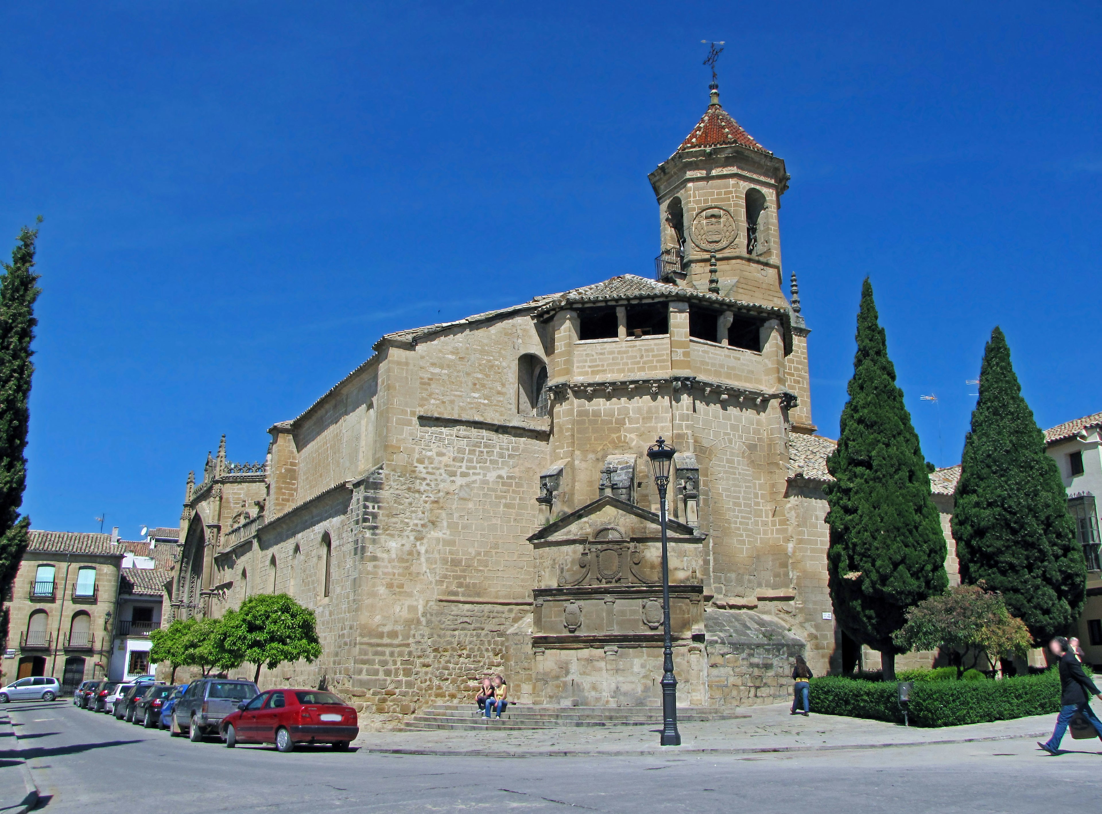 Exterior de una iglesia histórica bajo un cielo azul con vegetación circundante