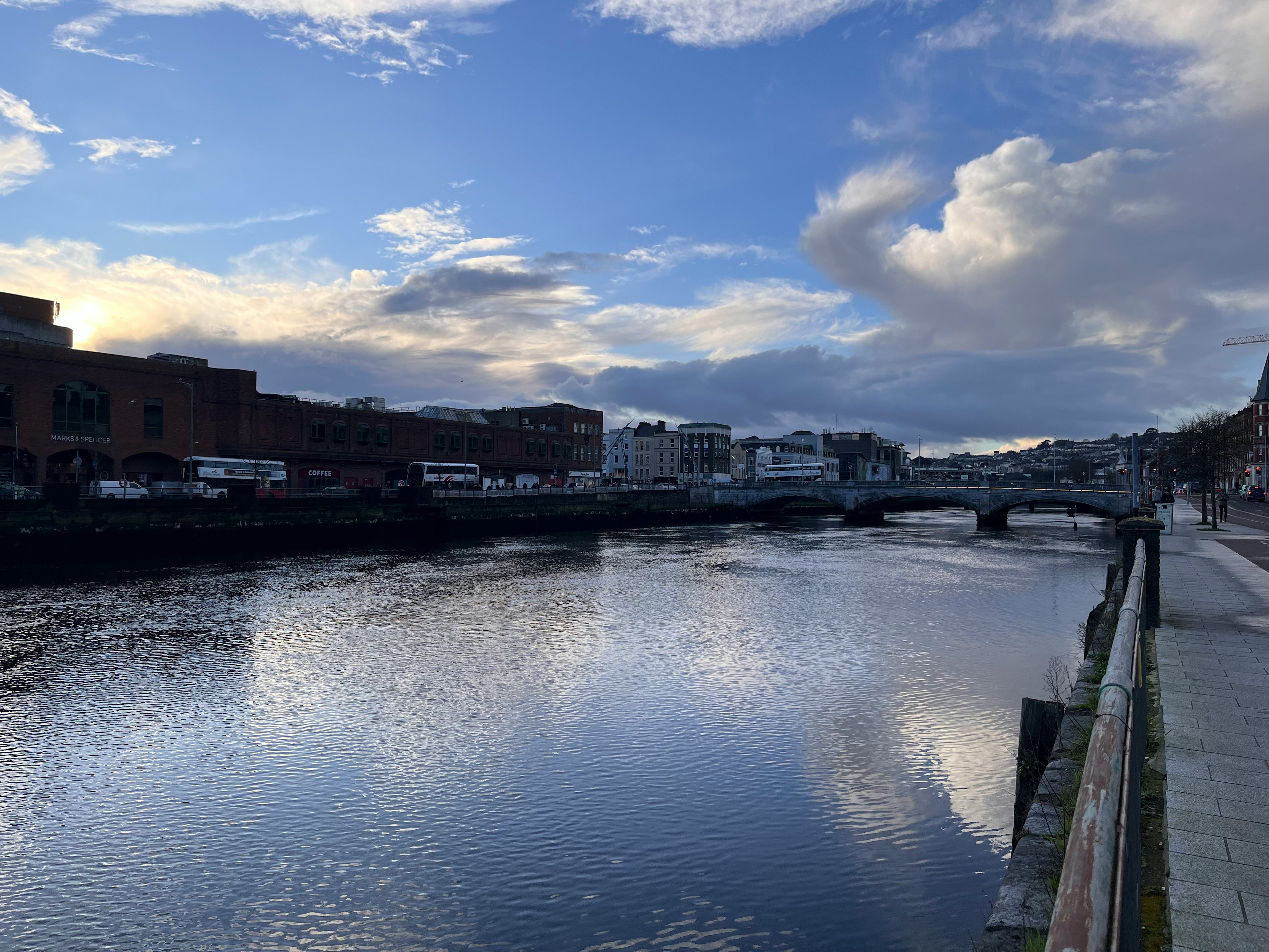 Calm river scene with blue sky and clouds reflecting on the water