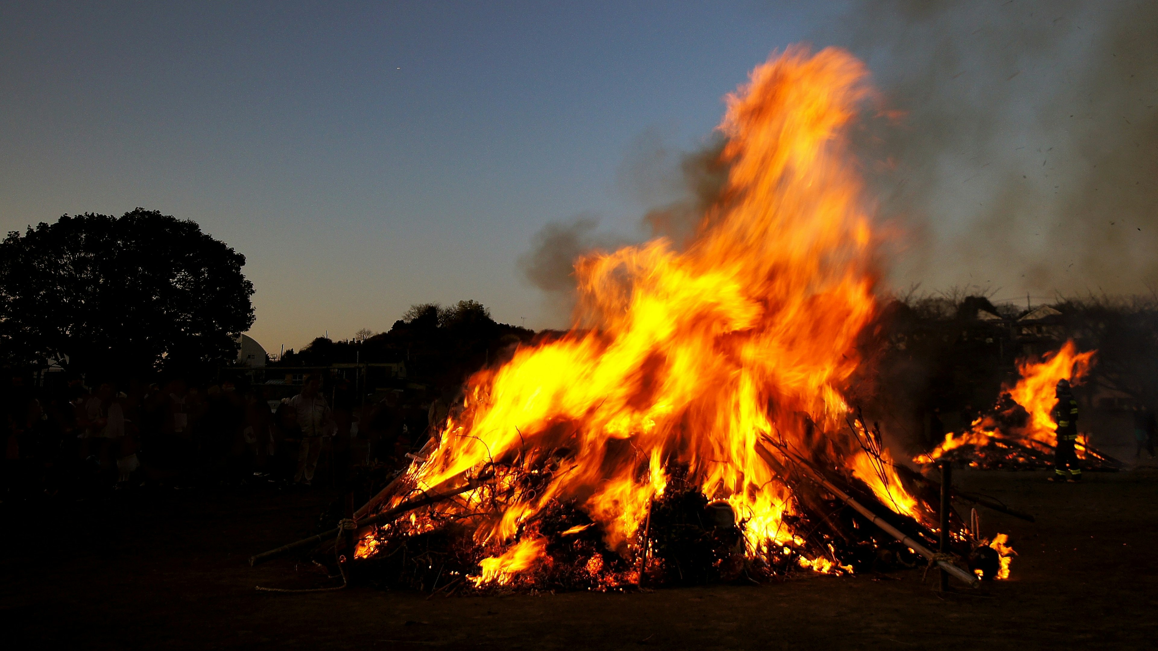 Una hoguera ardiendo intensamente bajo un cielo crepuscular