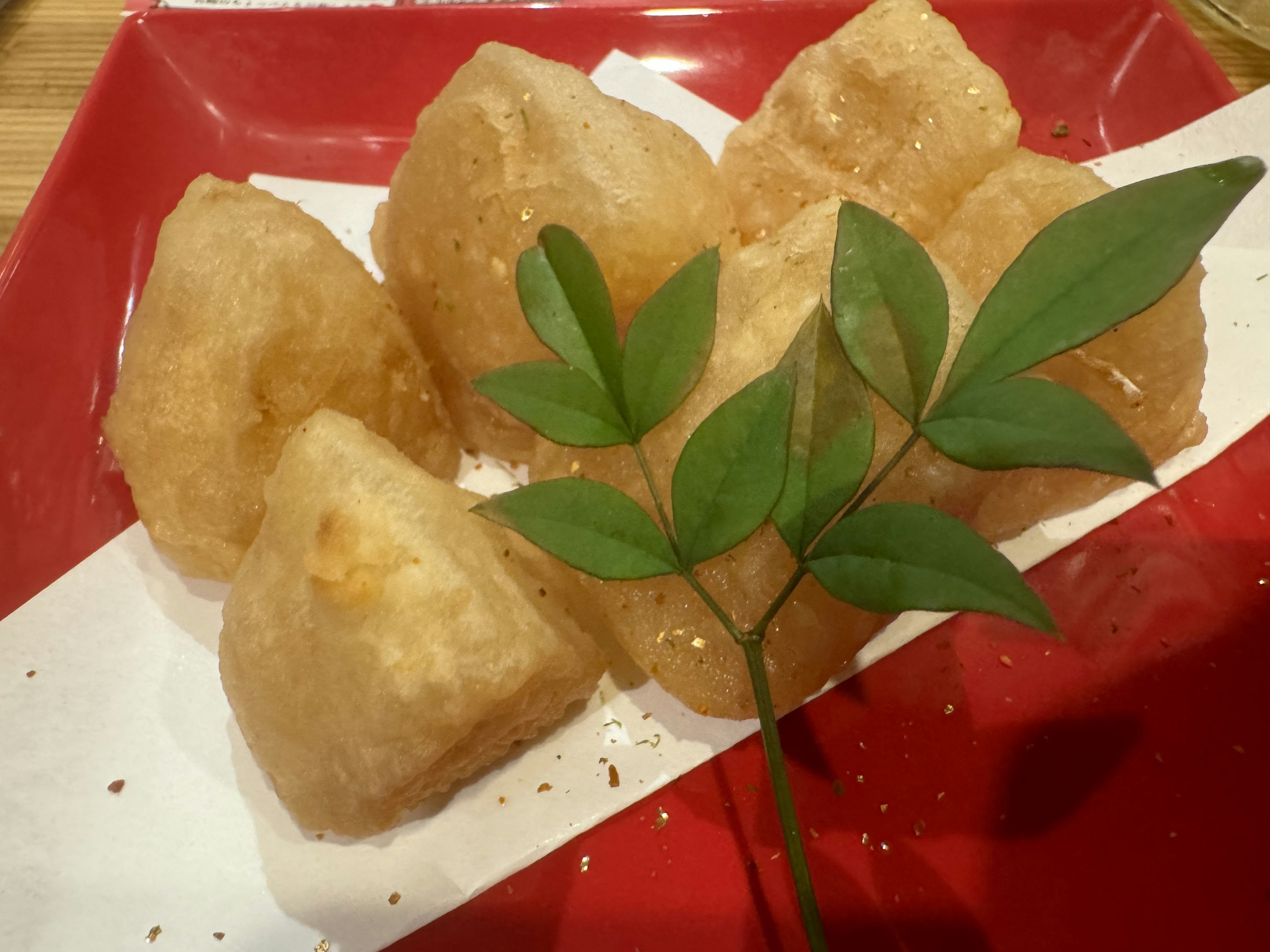 Fried dumpling-shaped food arranged on a red plate