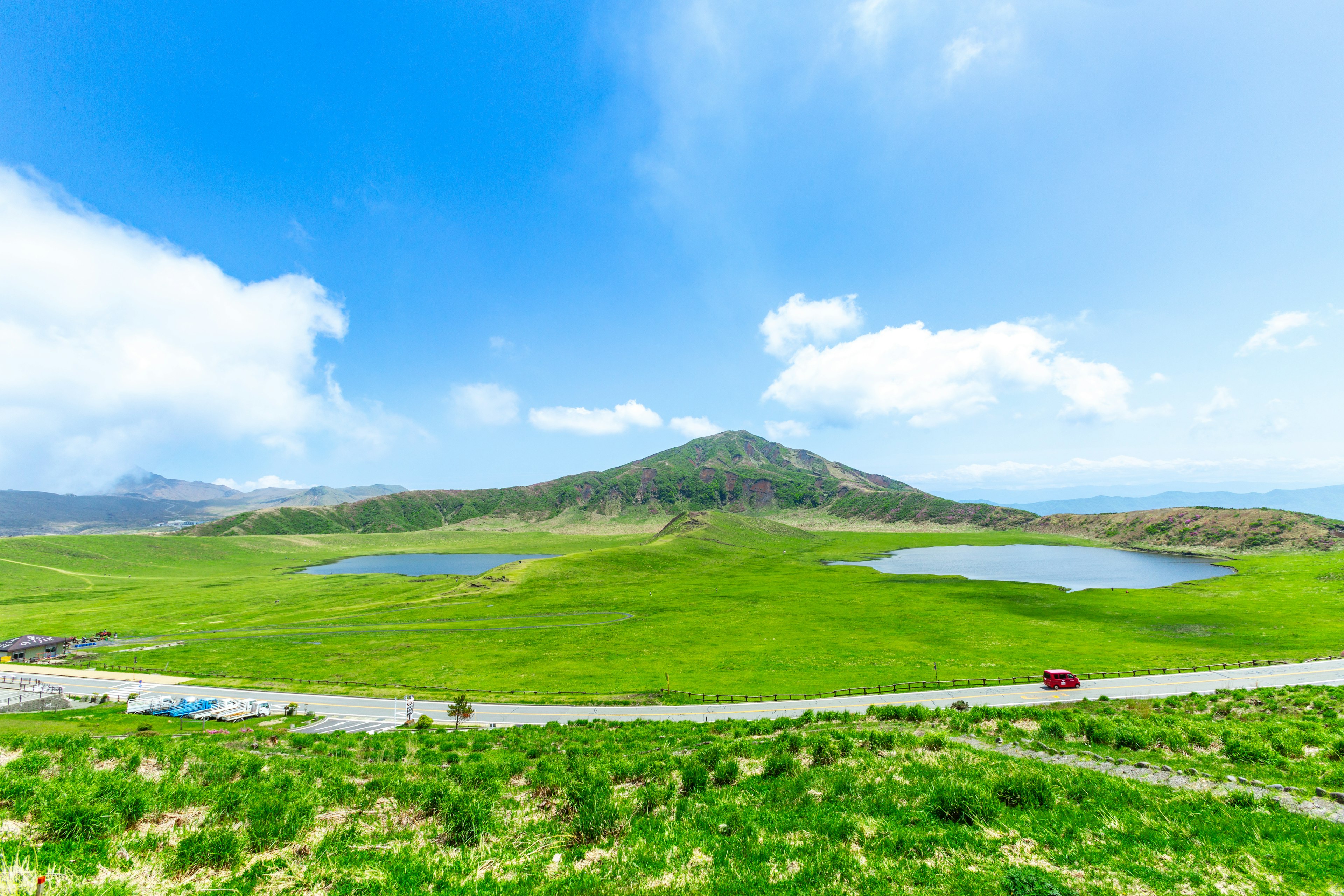 緑の大地と青い空の風景に小さな湖が点在する風景