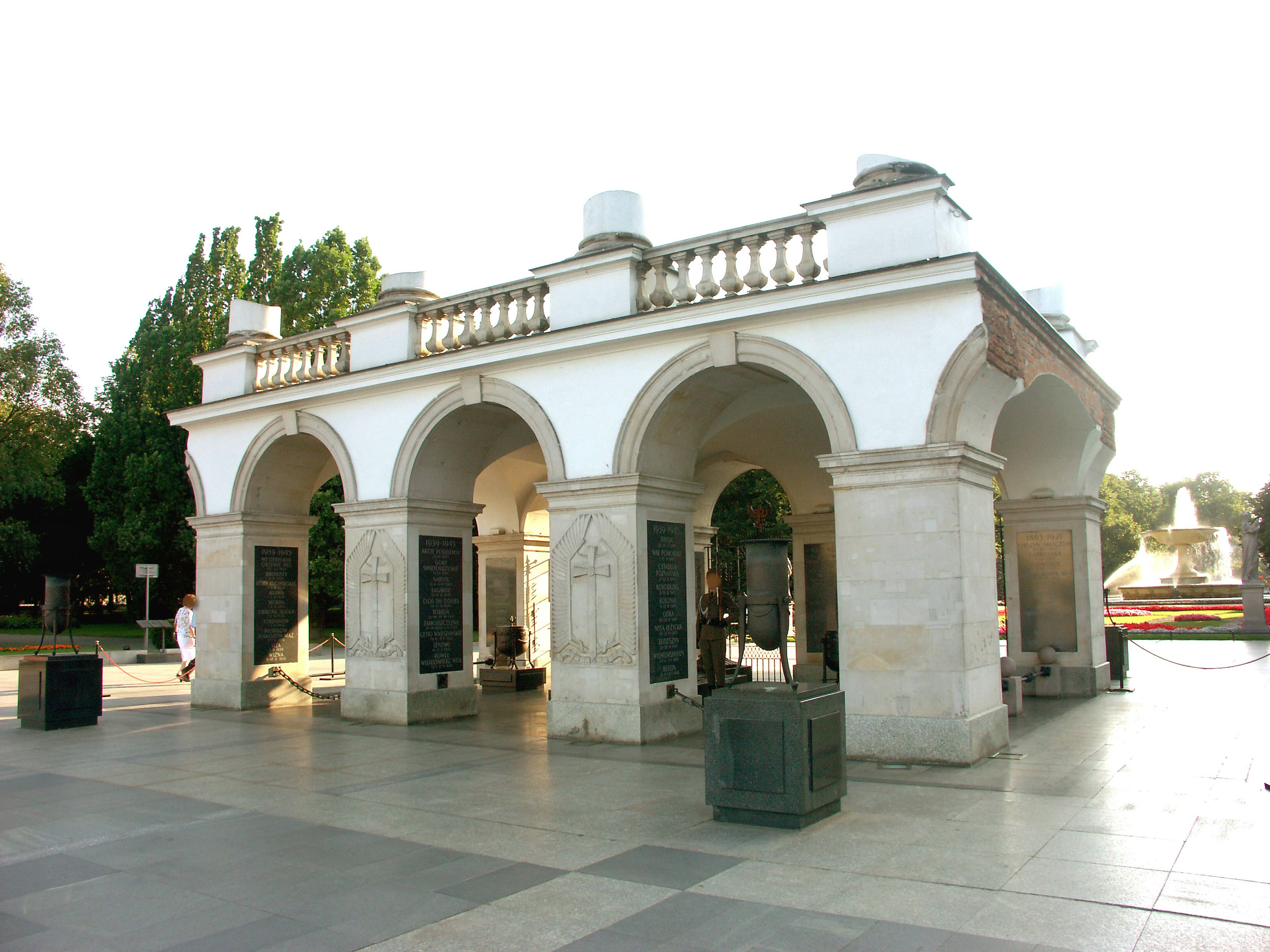 White archway structure in a park with green trees