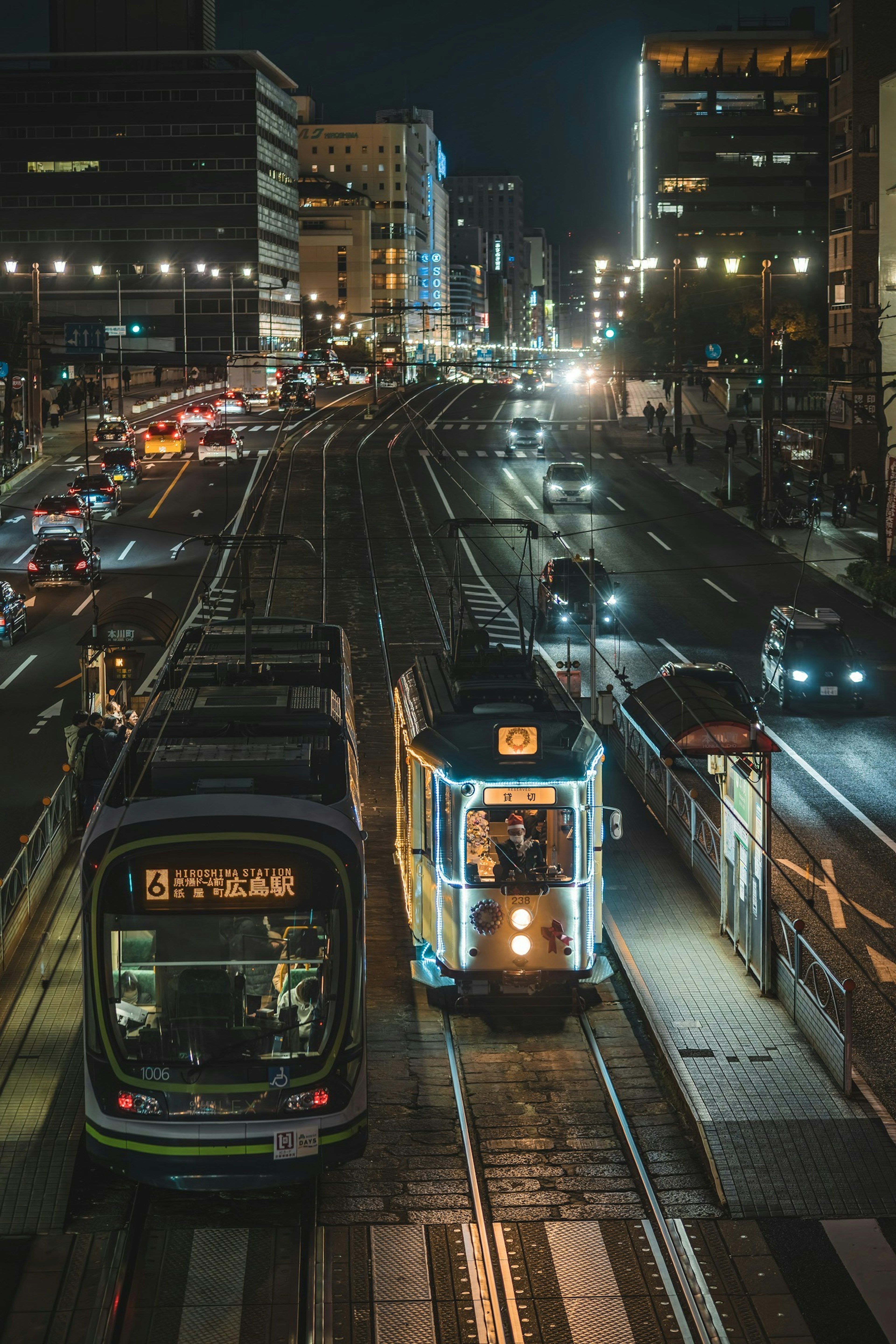 Paisaje urbano nocturno con tranvías y vehículos en una intersección