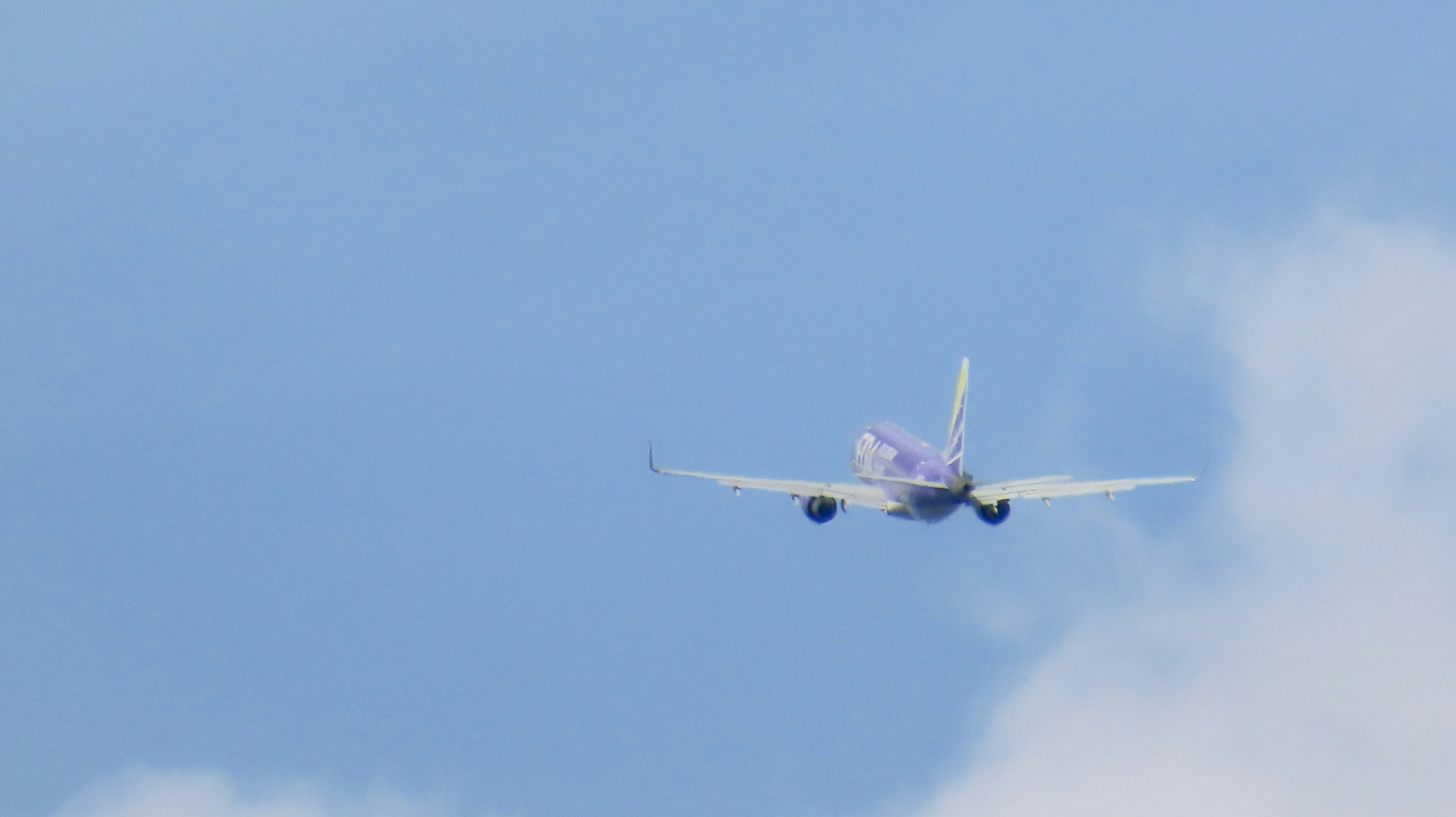 Ein Flugzeug fliegt vor einem blauen Himmel