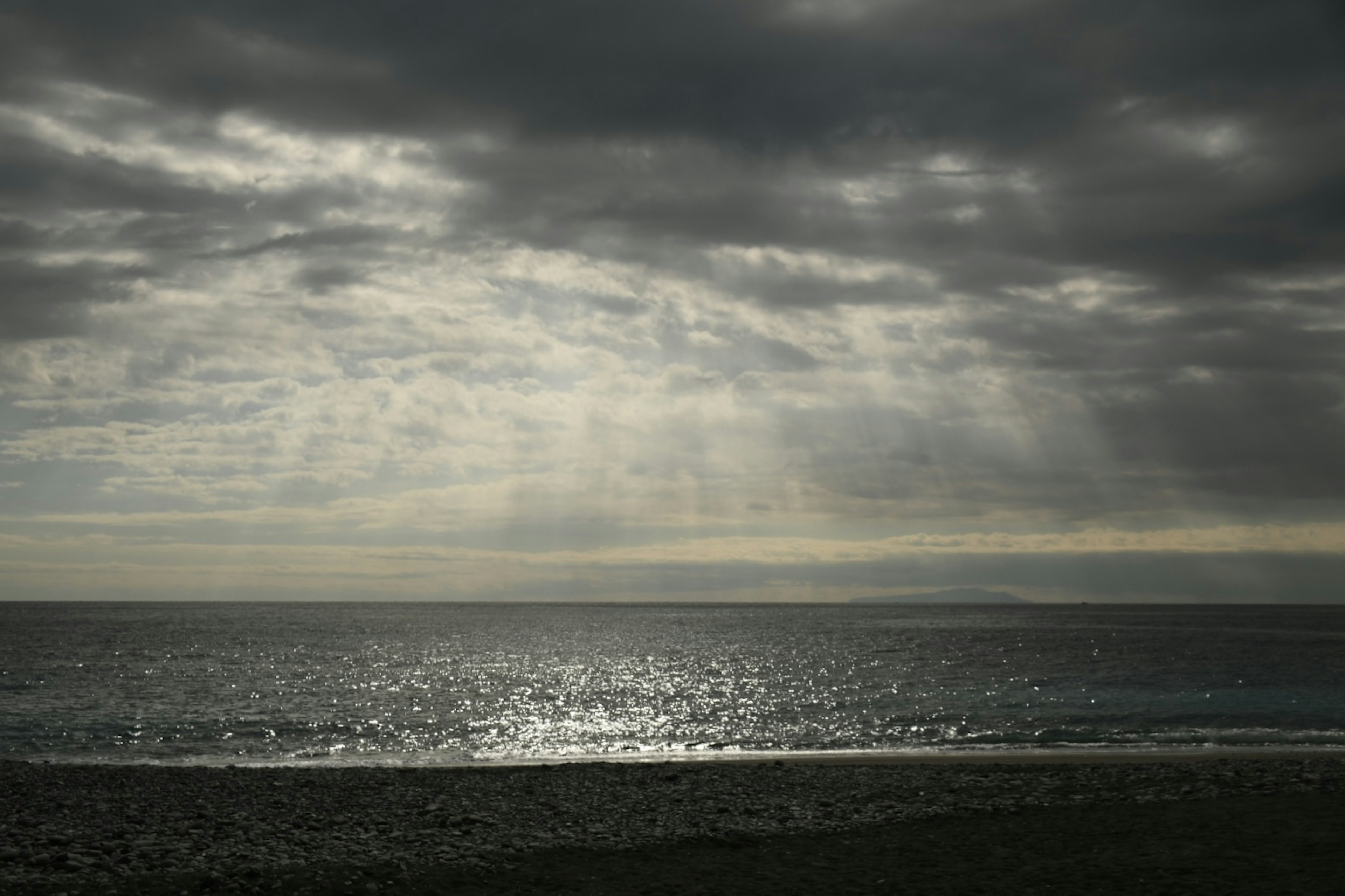 Dramatischer Himmel mit Lichtstrahlen, die die Meeresoberfläche beleuchten