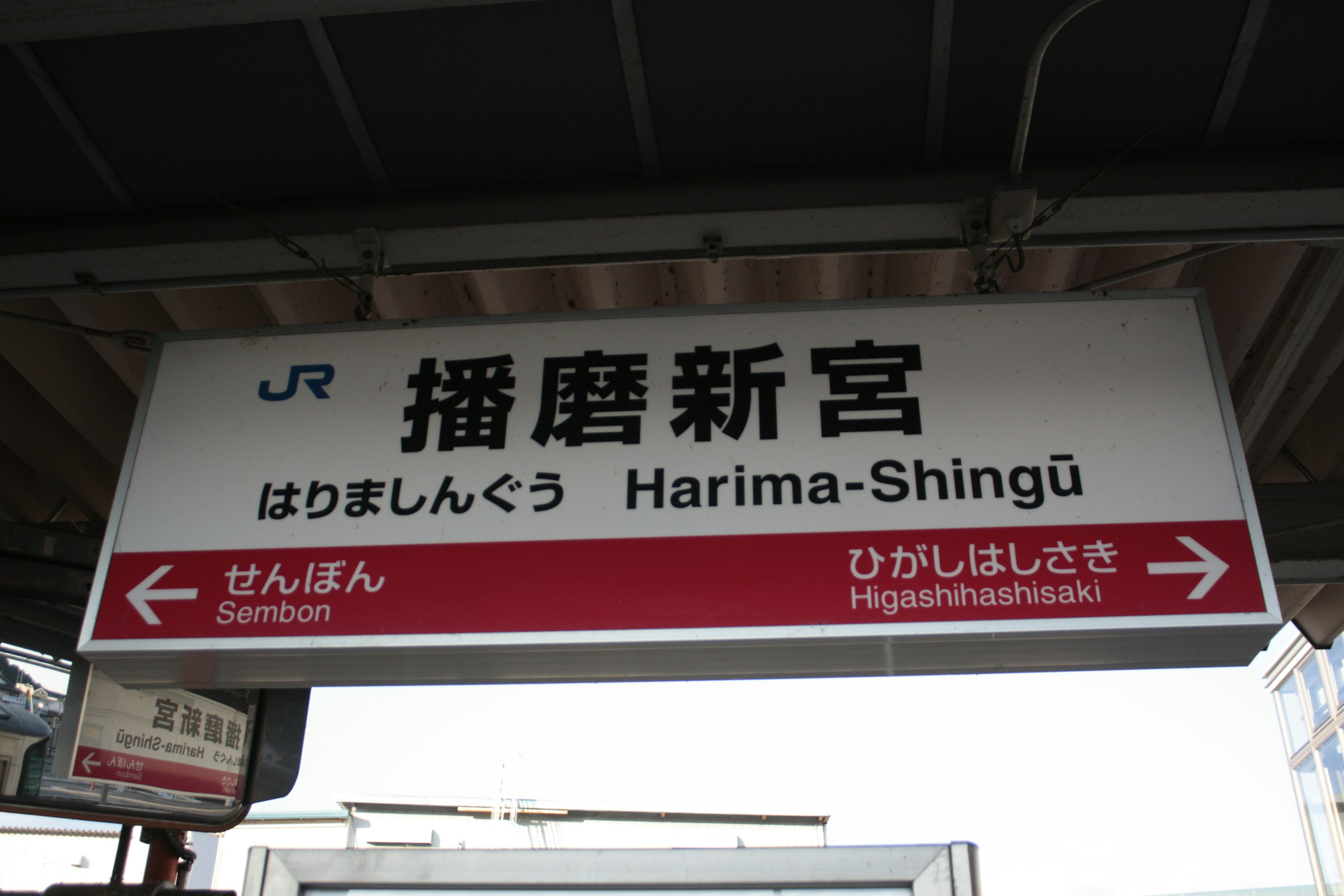 Cartel de la estación Harima-Shingū con nombres en japonés e inglés