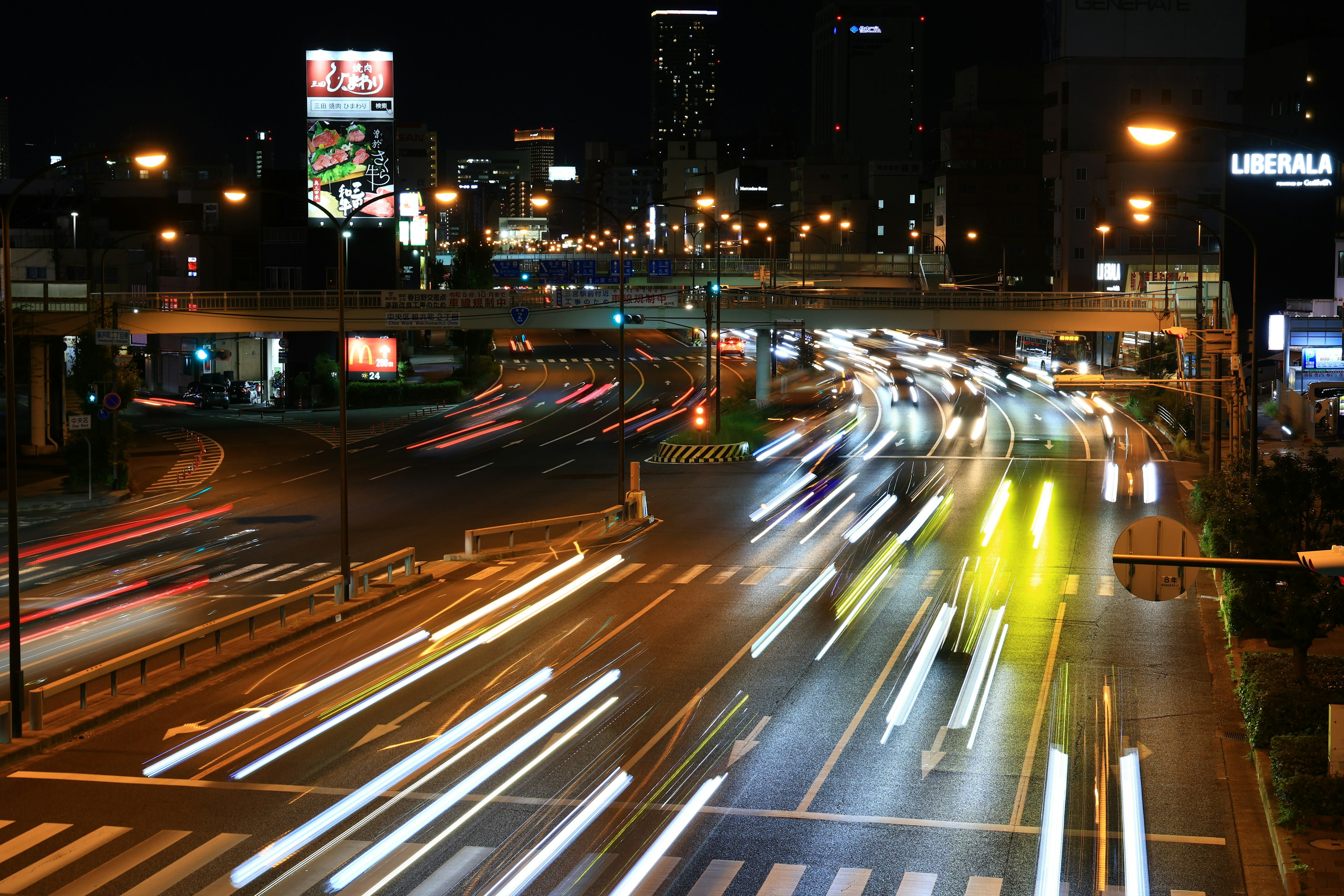 Pemandangan kota malam dengan lampu mobil mengalir dan pemandangan persimpangan