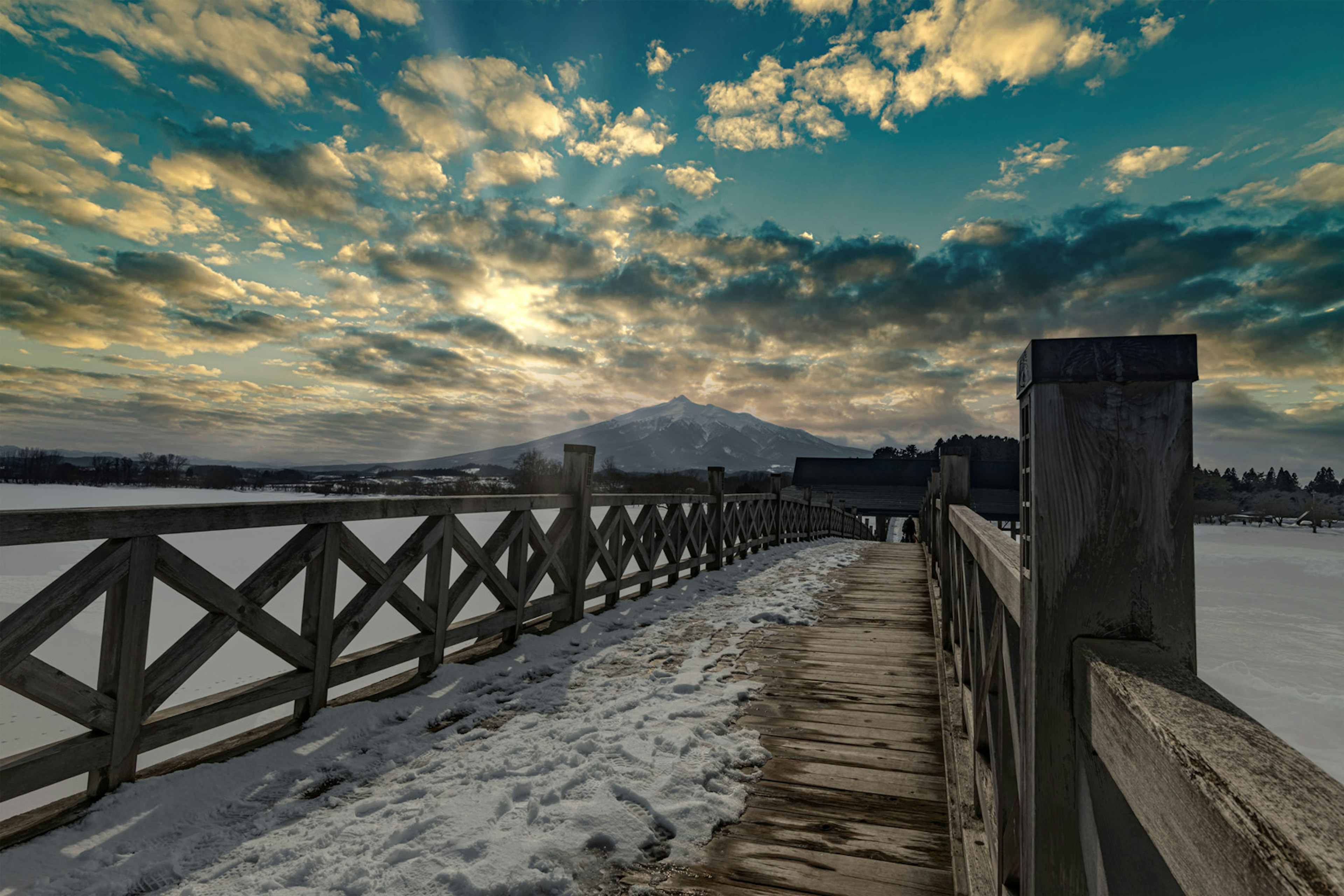 Snow-covered walkway with a vibrant sky and clouds