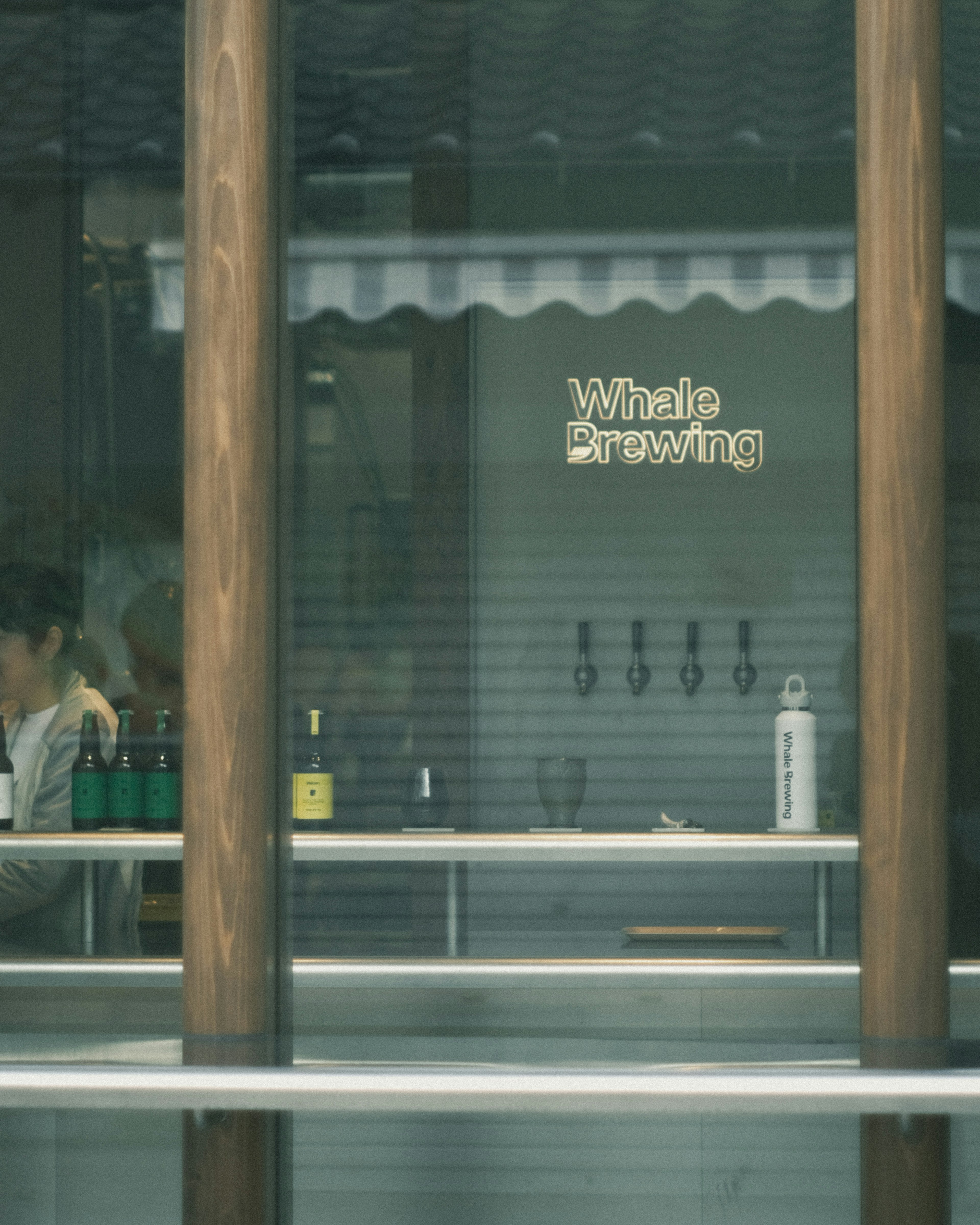 Silhouette of a woman in front of a whiskey brewing window with a counter