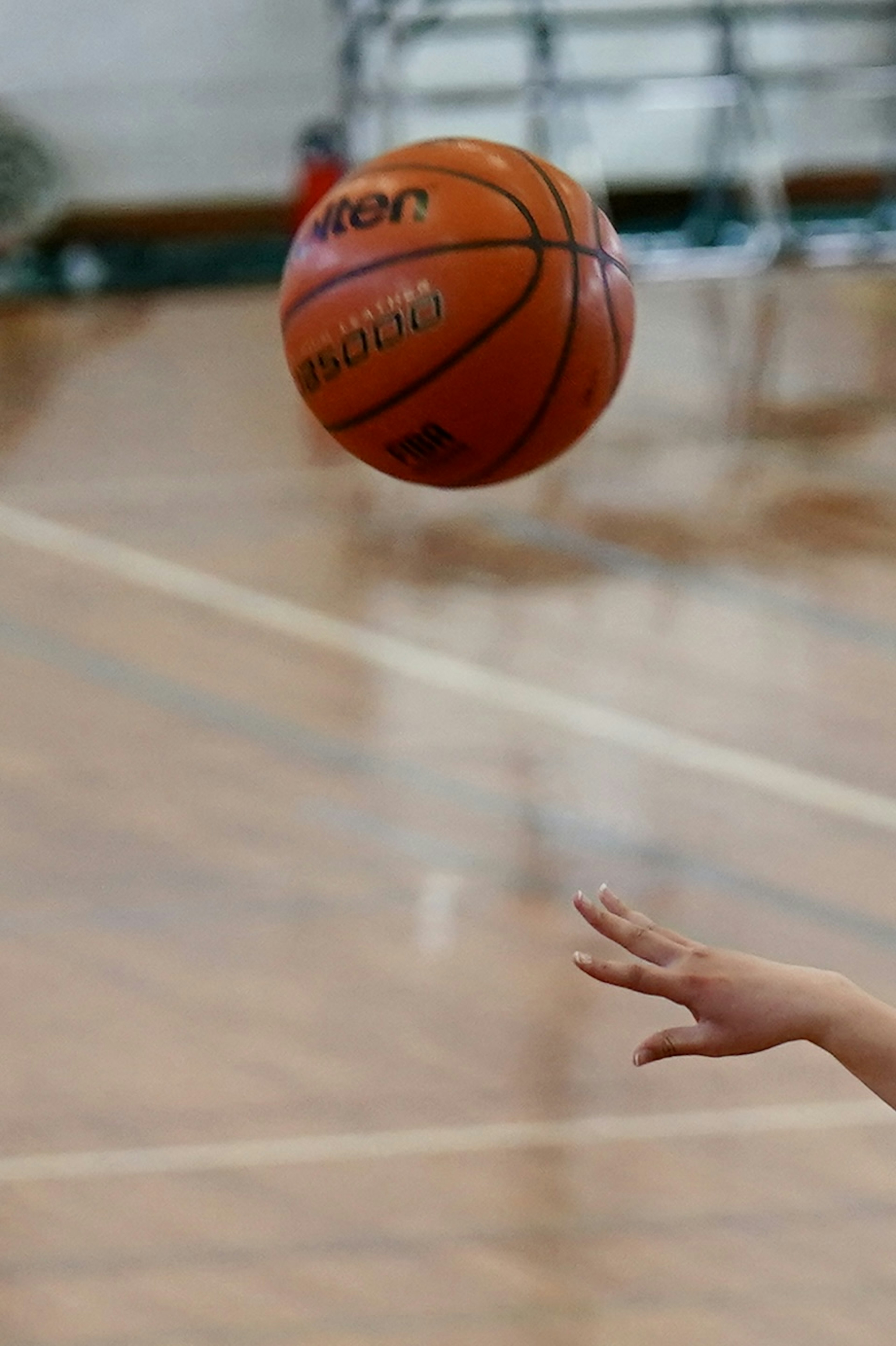 Un ballon de basket en l'air avec une main qui l'atteint