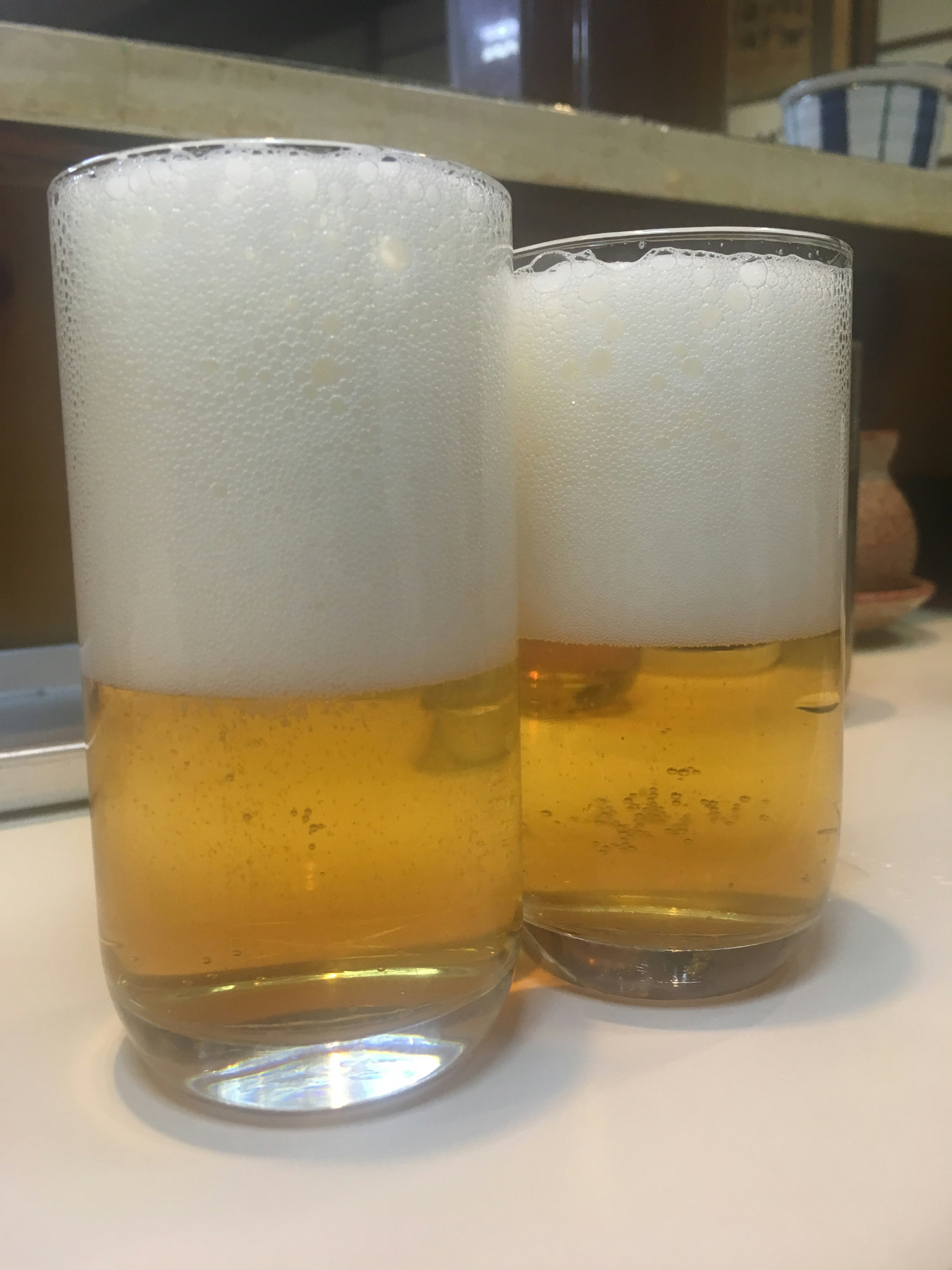 Deux verres de bière avec des têtes mousseuses