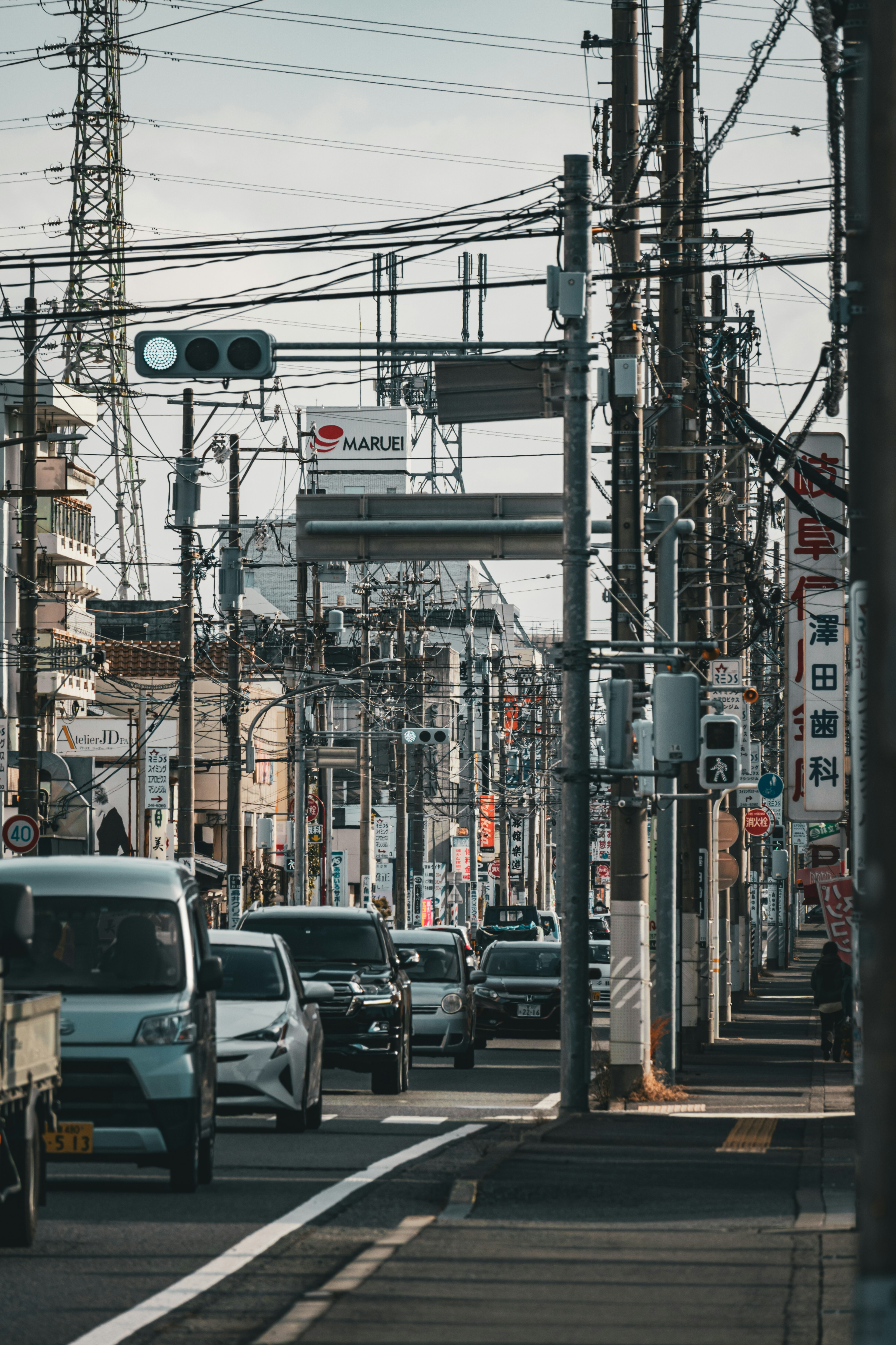 日本の街中の道路に沿った車両と電線の風景