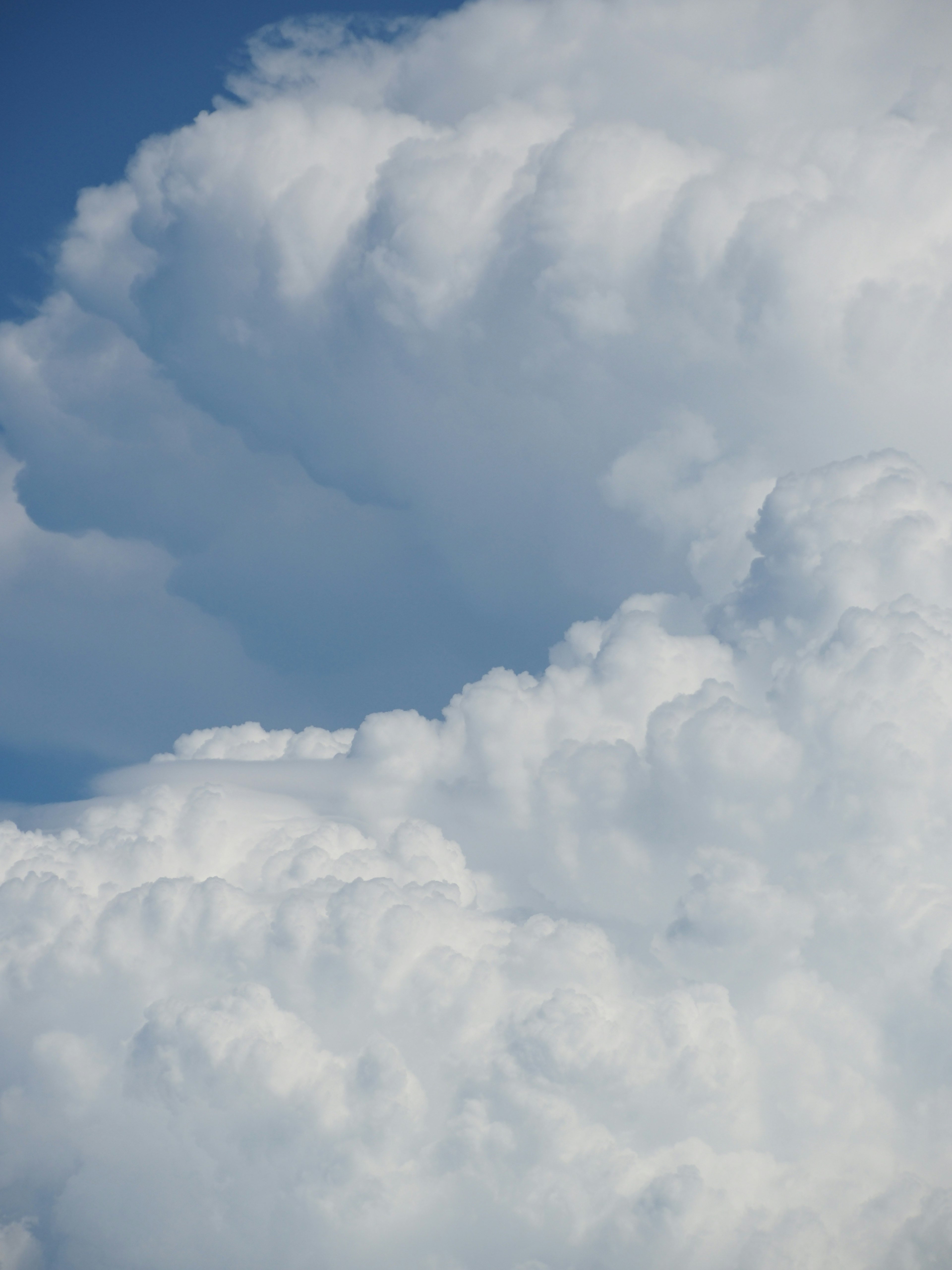 Textured white clouds against a blue sky