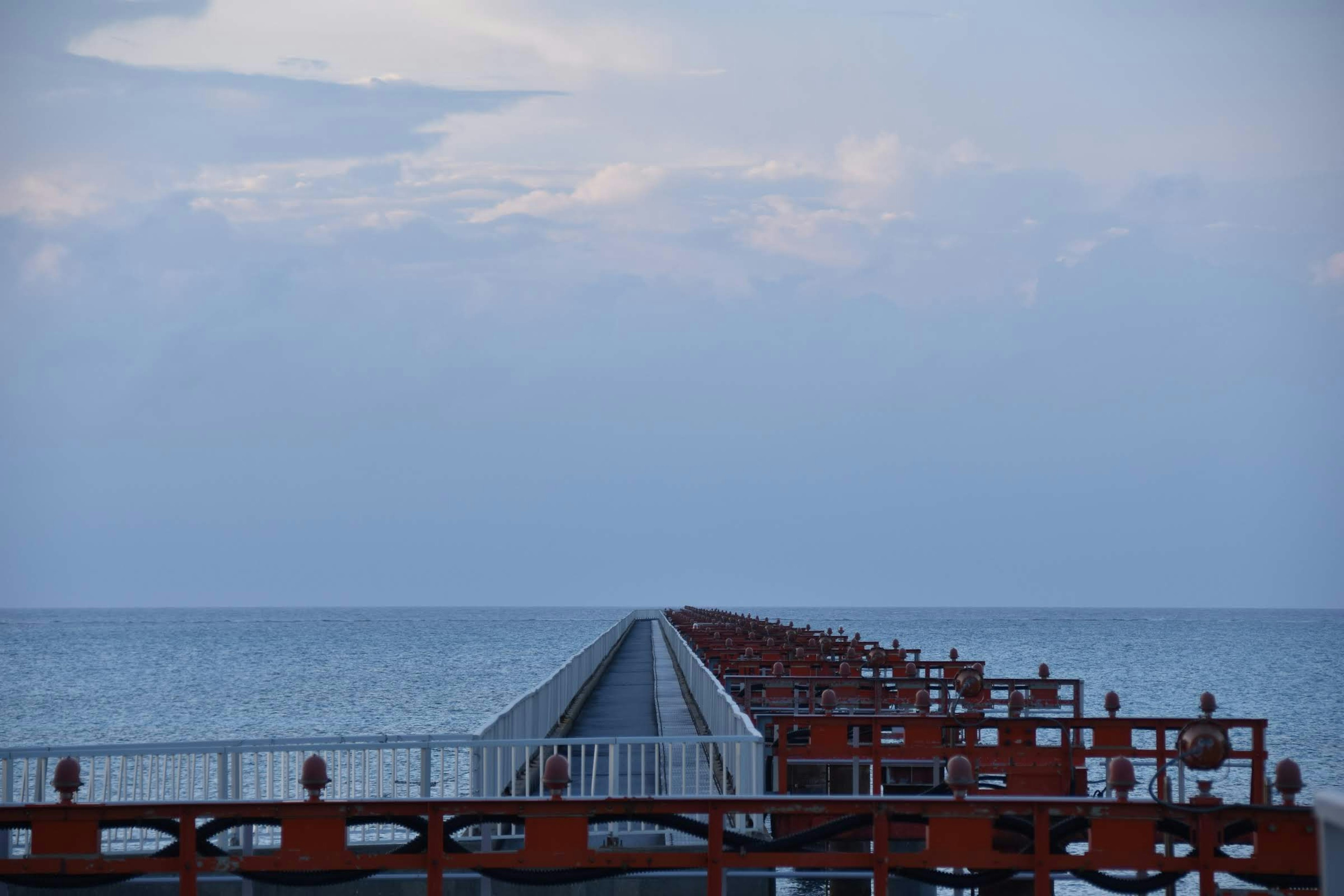 Blick auf einen roten Pier, der ins Meer ragt