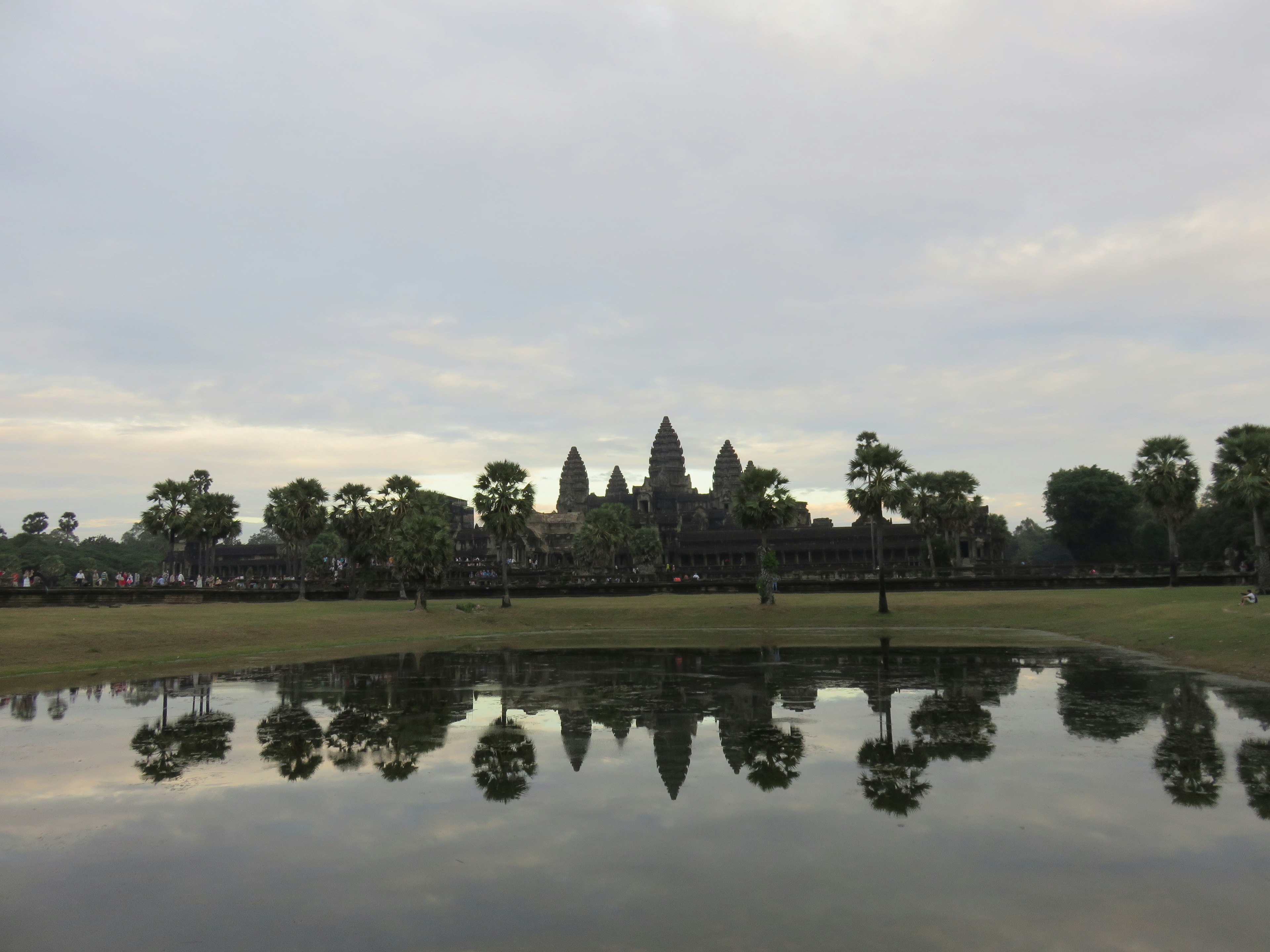 Reflexion von Angkor Wat in einem ruhigen Teich umgeben von Bäumen