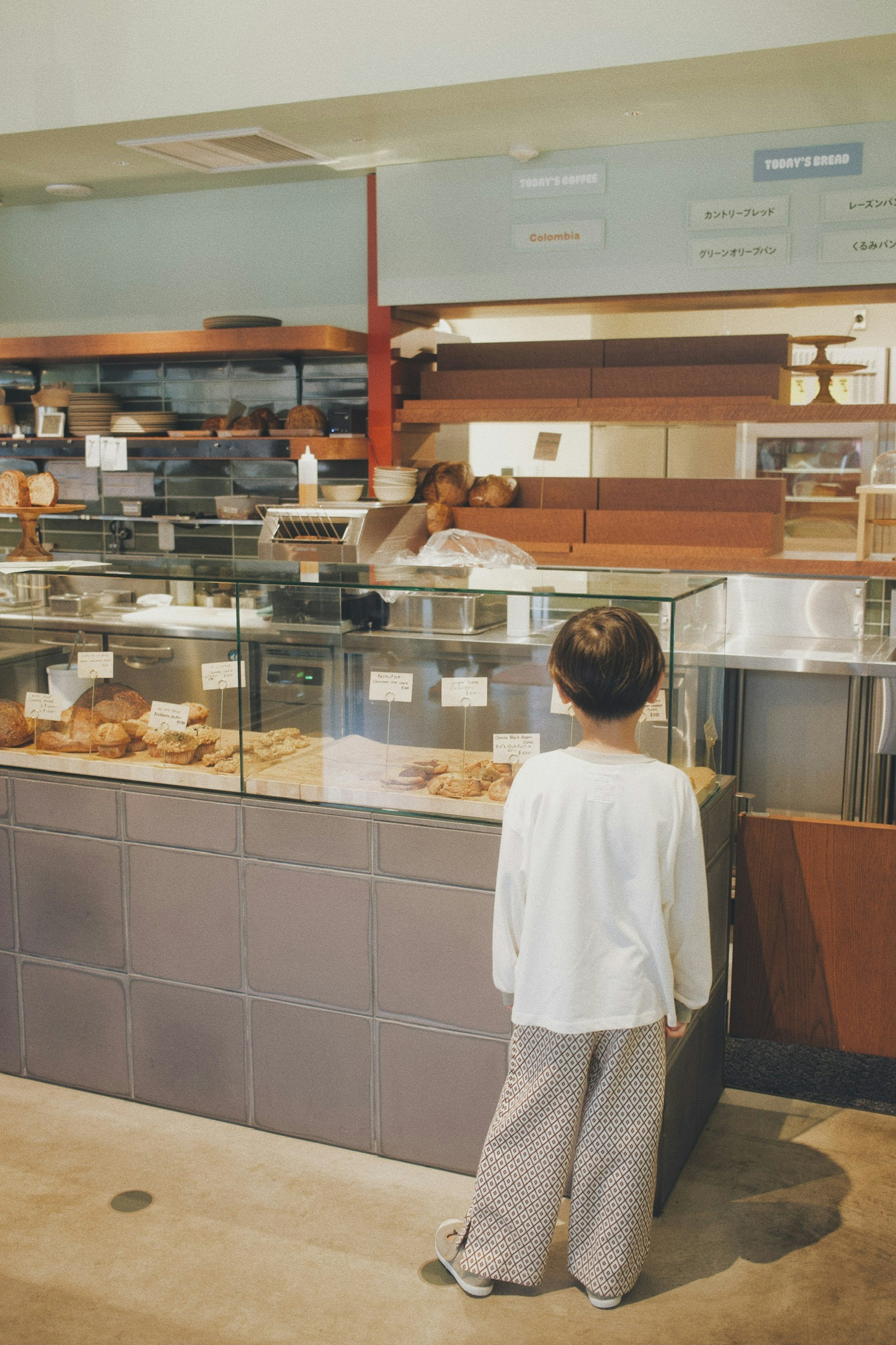 Ein Kind schaut auf die Bäckereivitrine