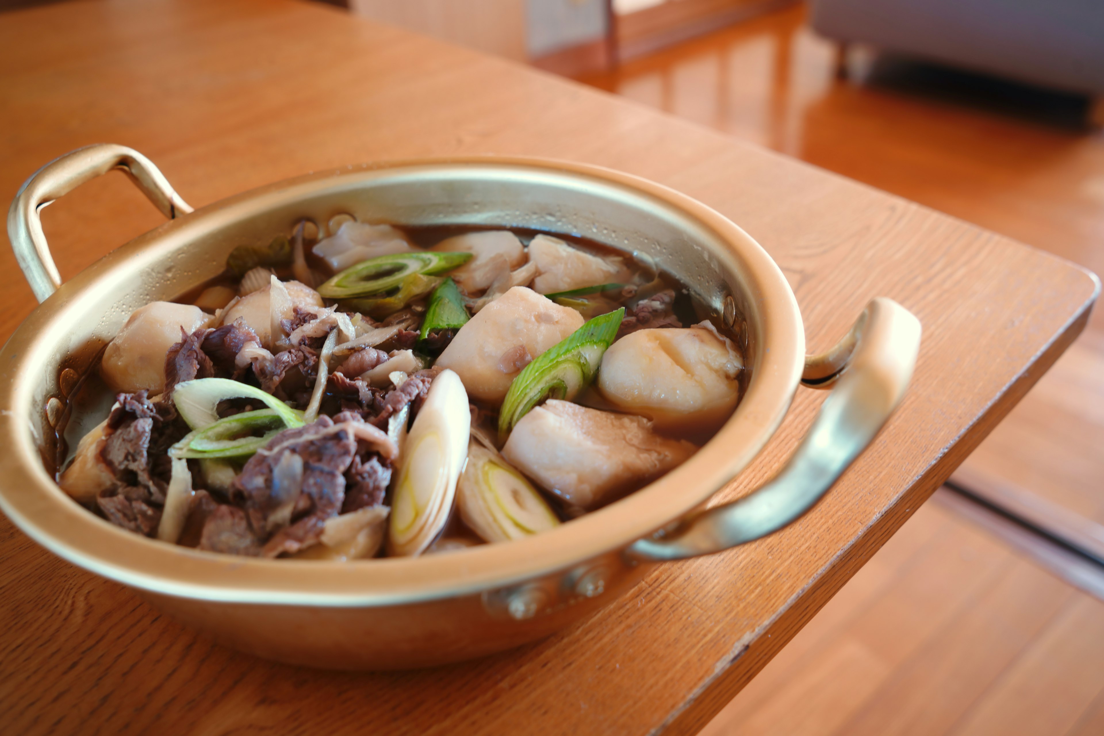 鍋に入った肉と野菜の料理 カラフルな盛り付けと木製テーブル