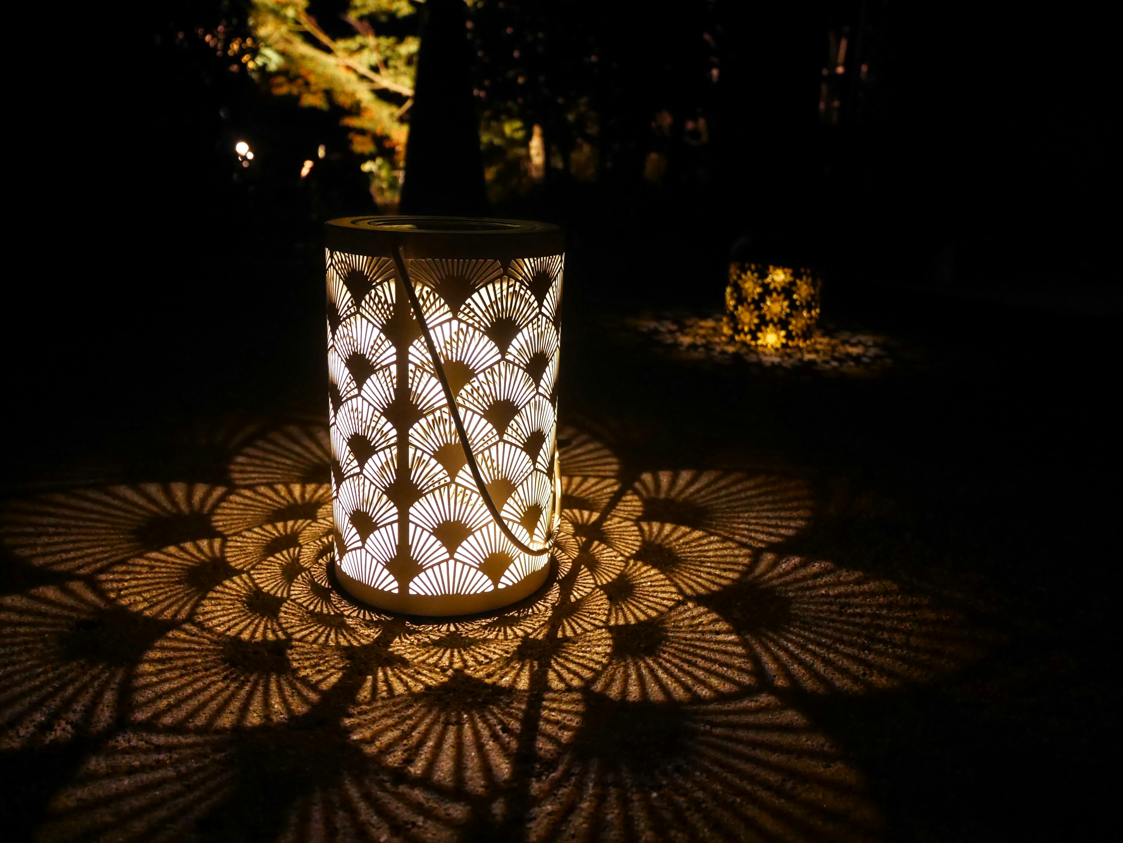 A bright lantern casting intricate patterns on a dark surface