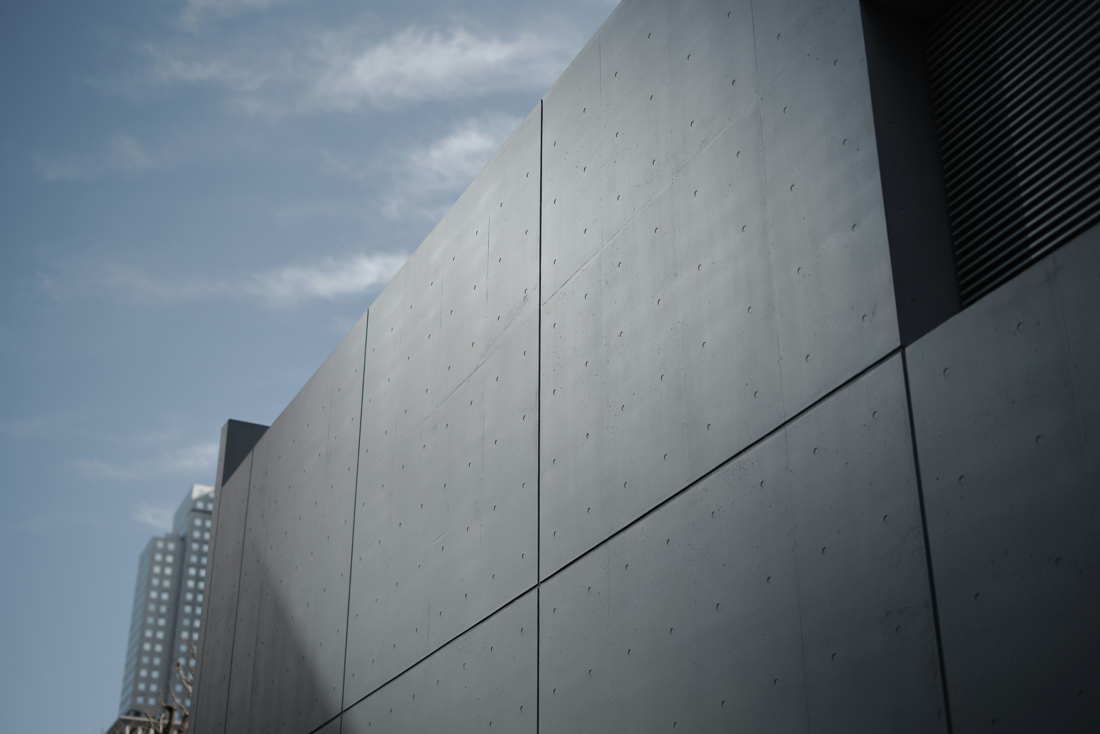 Mur d'un bâtiment moderne gris avec un ciel bleu