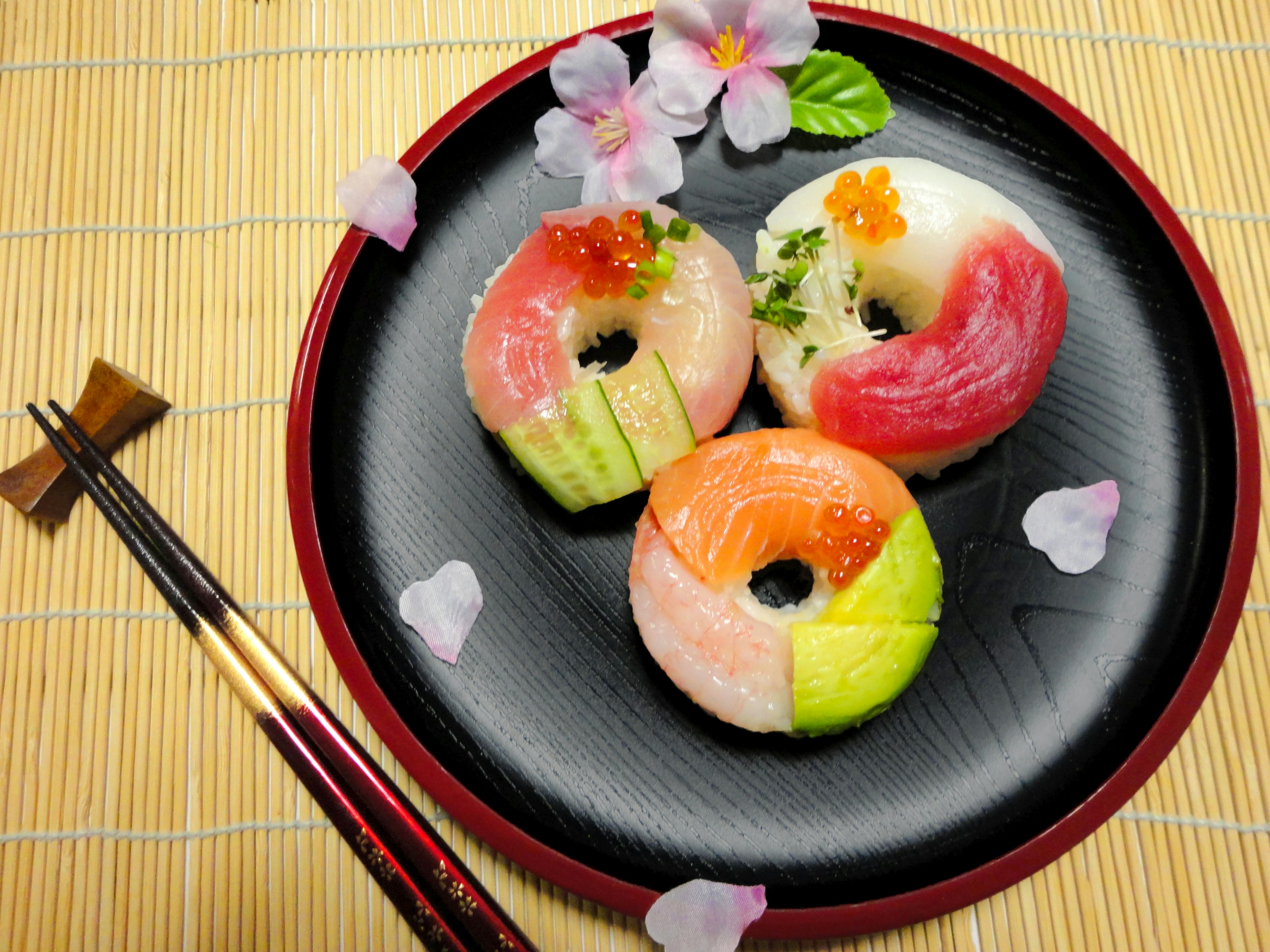 Piring sushi yang indah tersusun di atas piring hitam