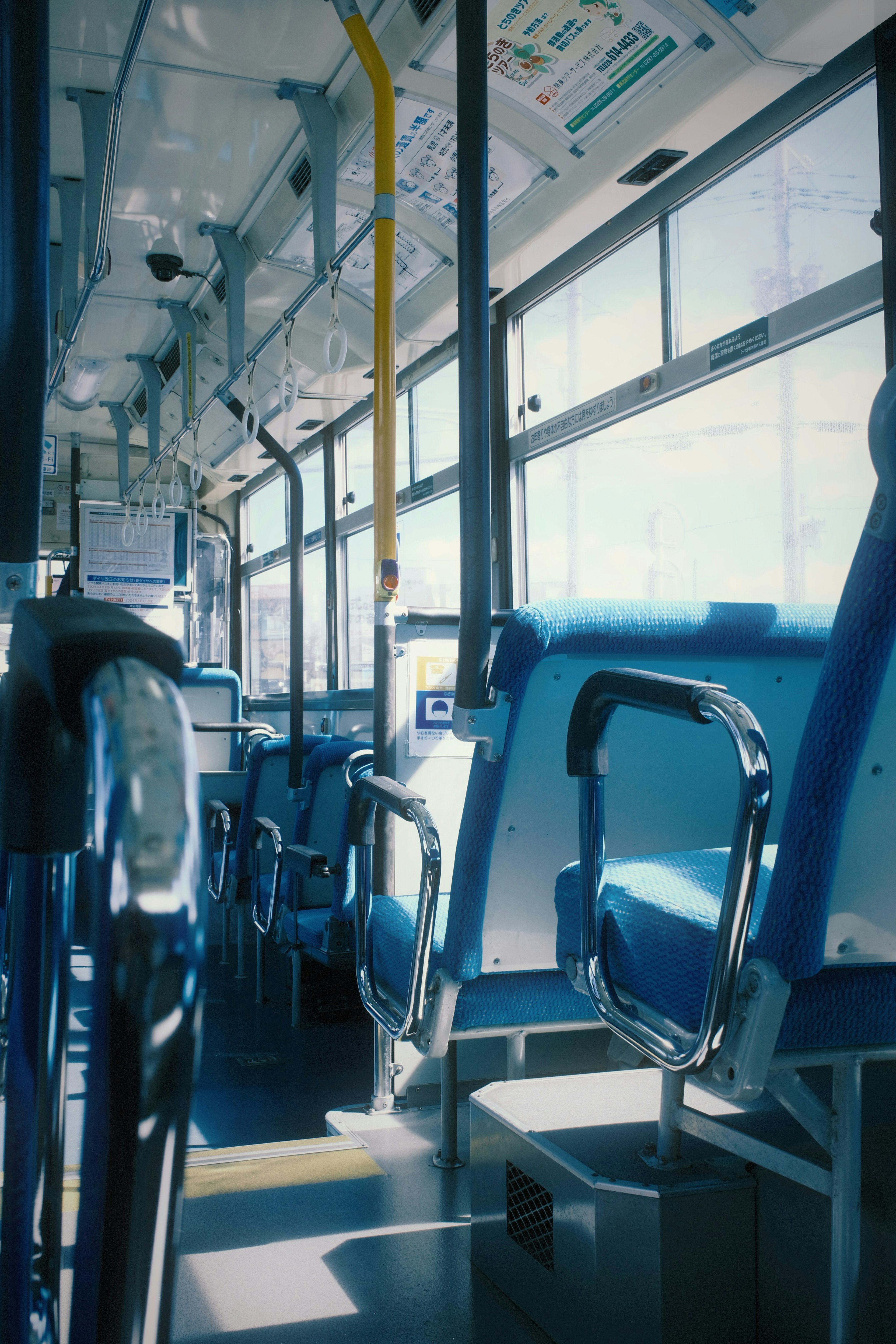 Interior of a bus with blue seats and bright windows