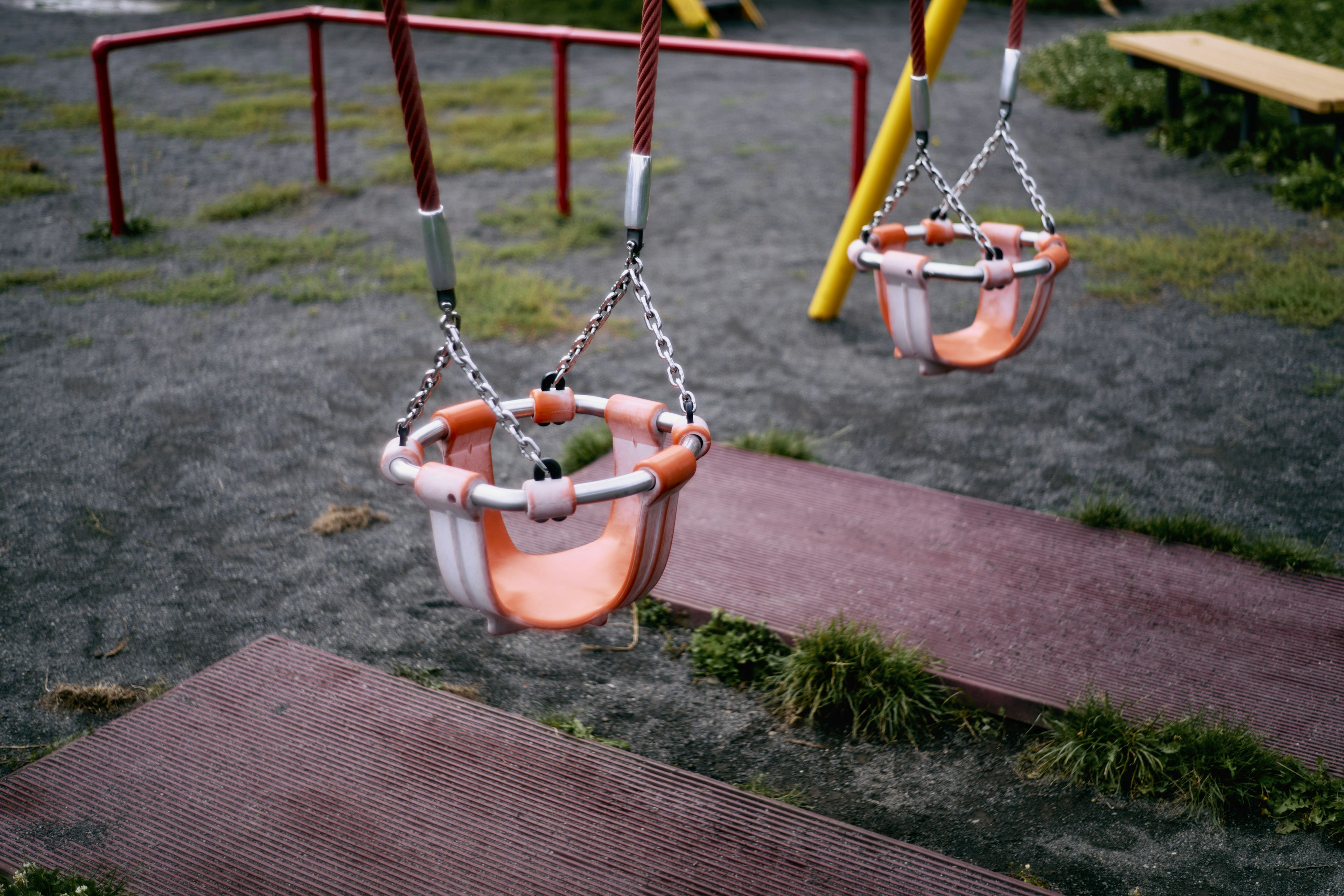 Schaukeln auf dem Spielplatz und Sandbereich