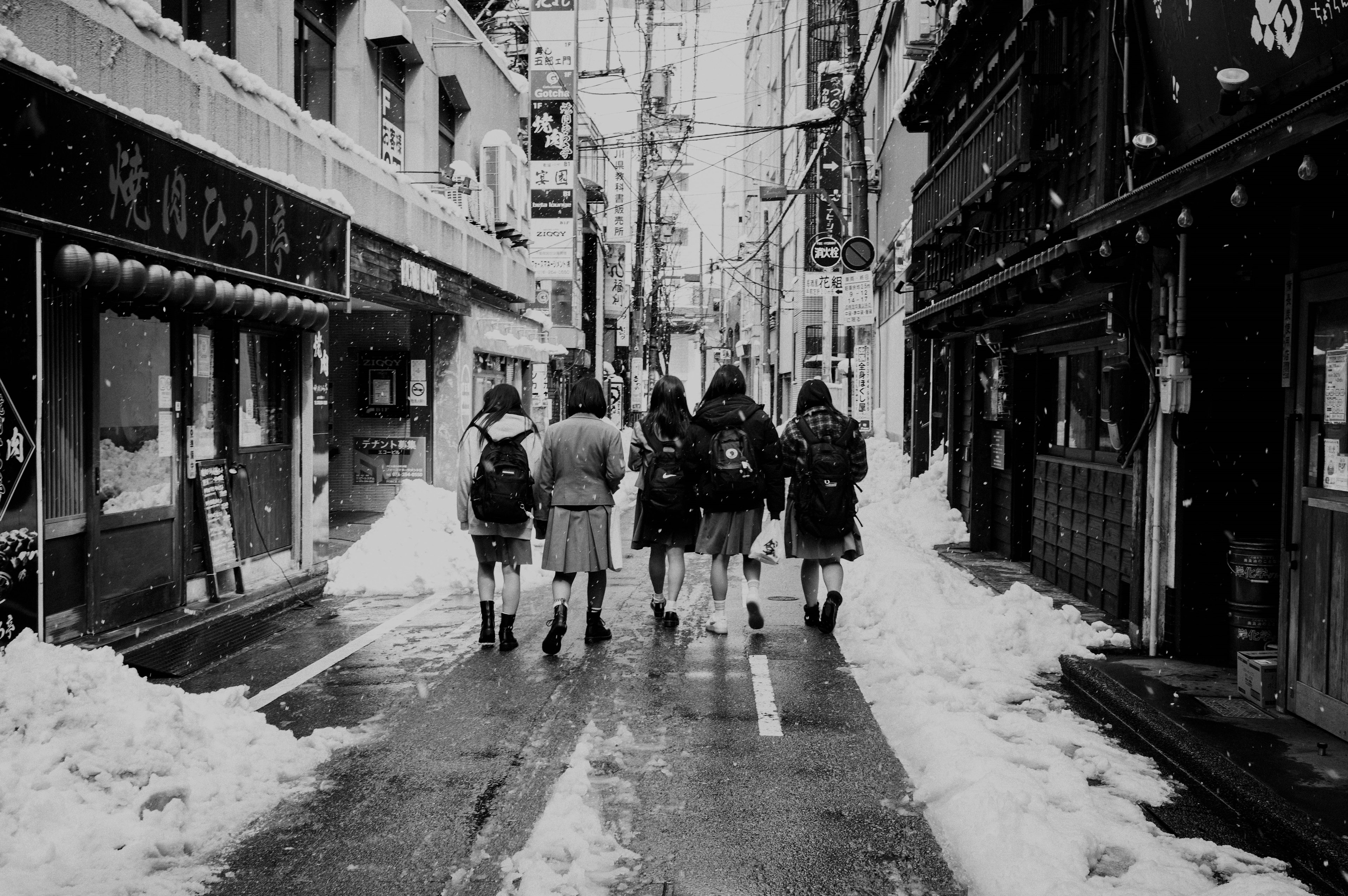 Foto in bianco e nero di studenti che camminano nella neve