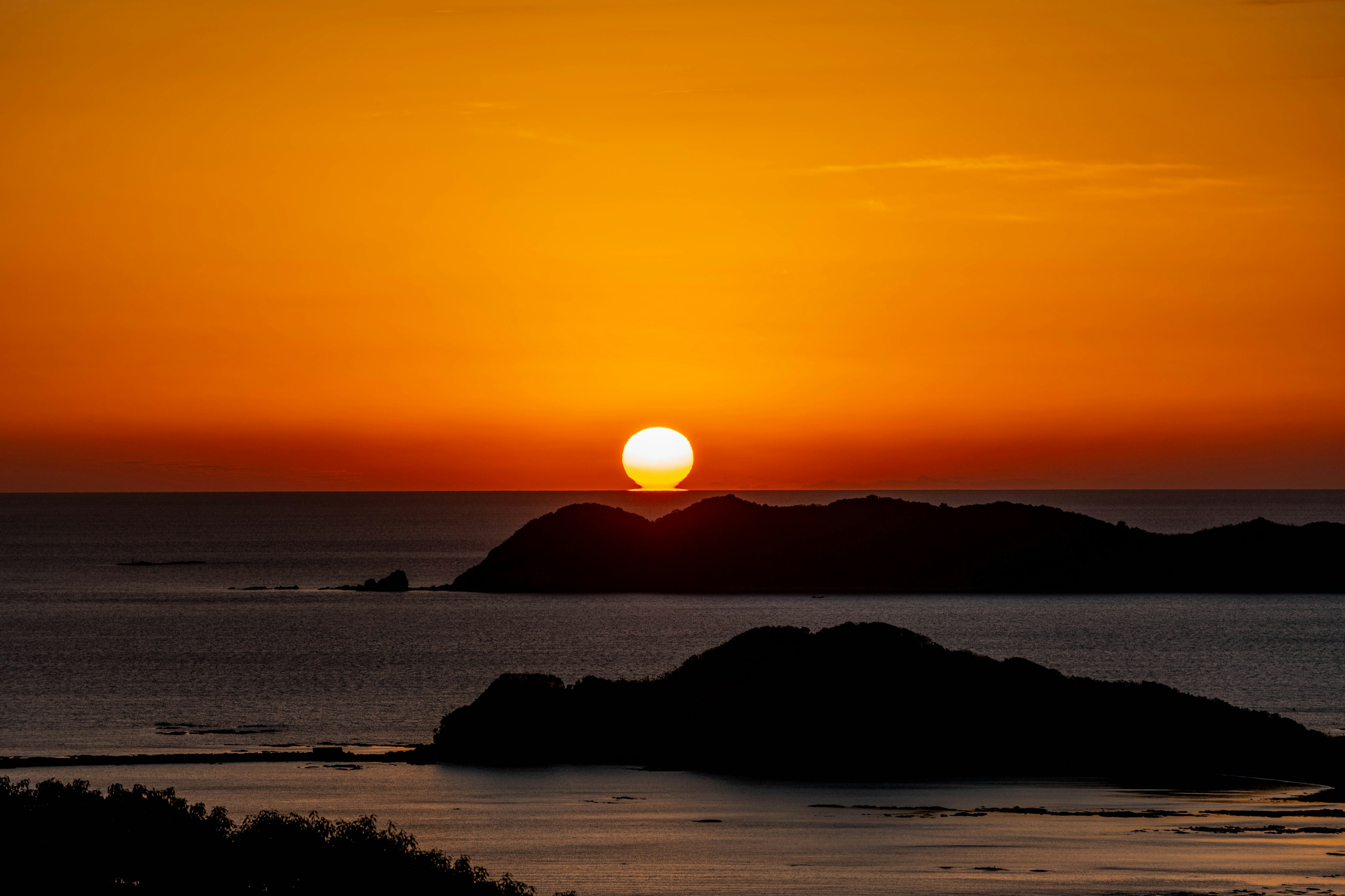 海に沈む夕日とオレンジ色の空