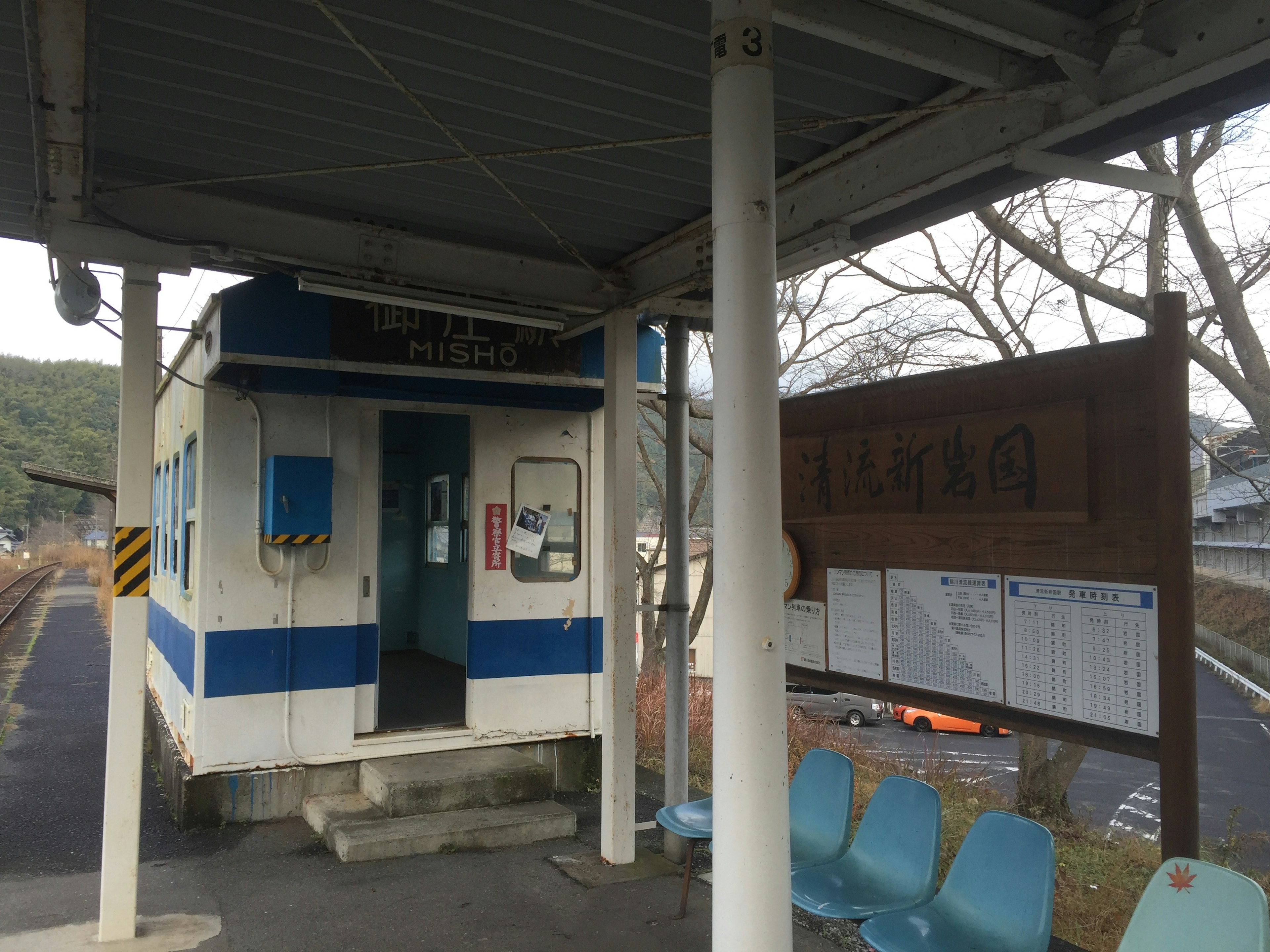 Small train station with waiting area and signboard