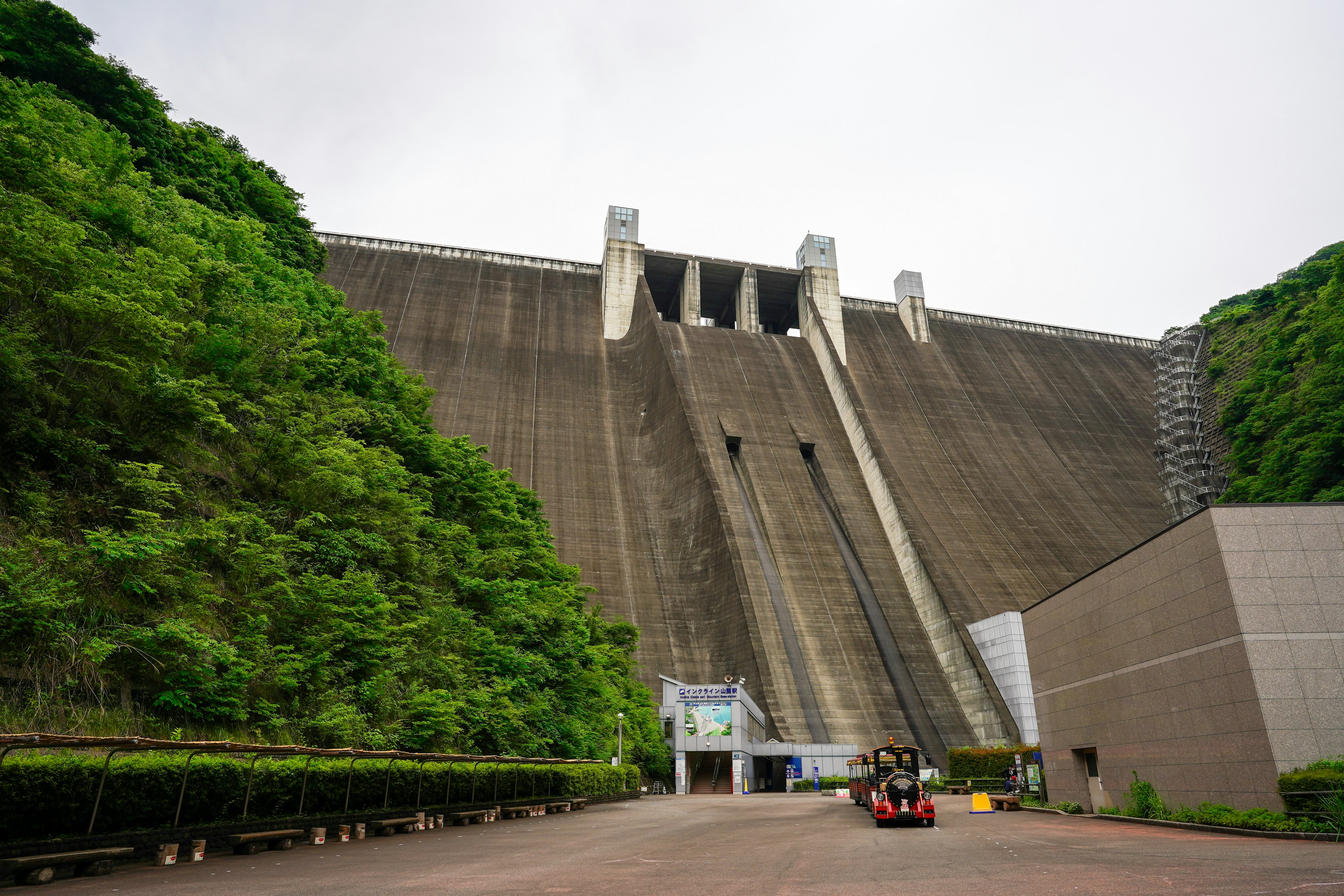 Gran estructura de represa rodeada de vegetación y área de entrada