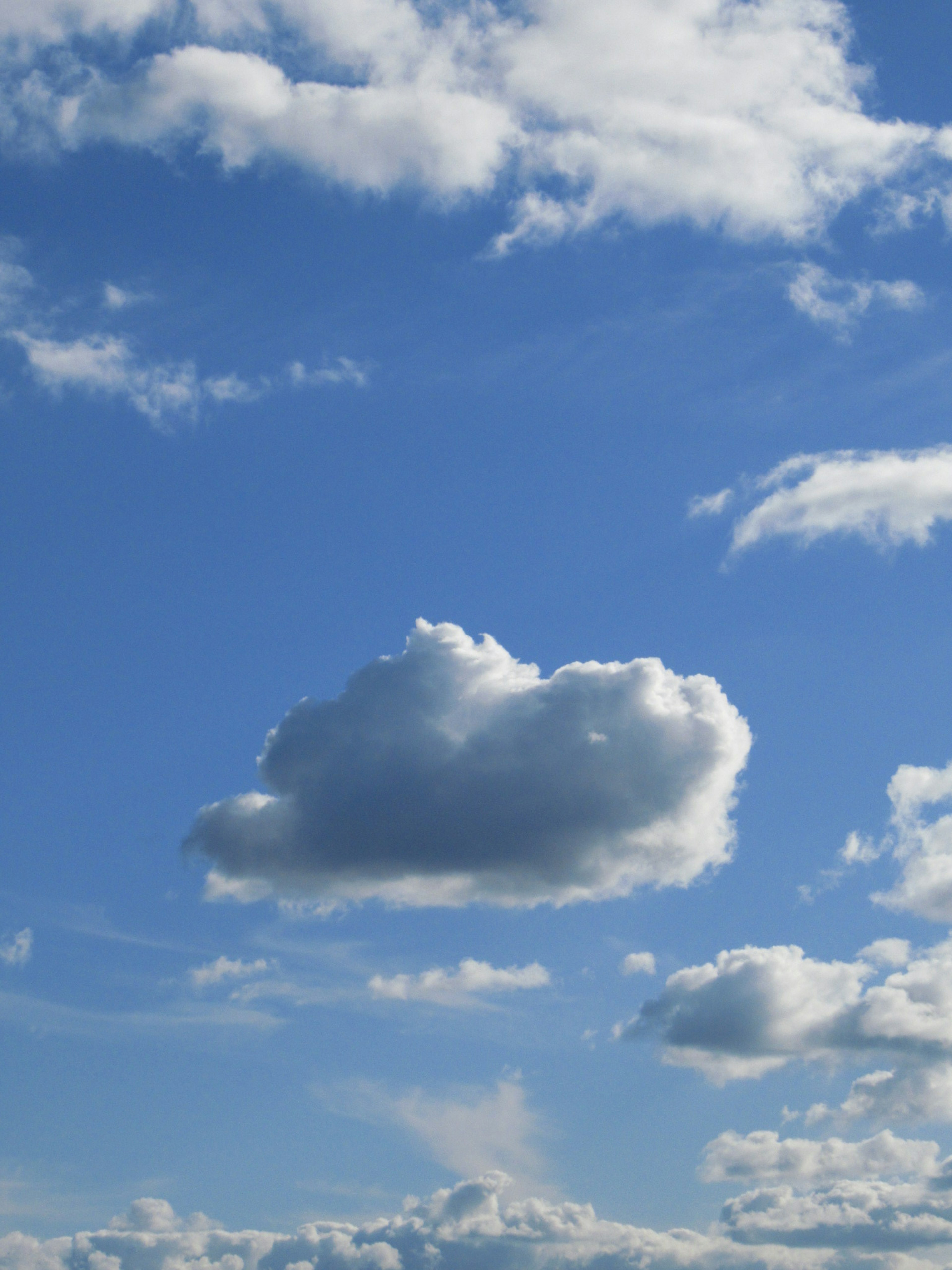 Awan putih berbulu mengapung di langit biru cerah