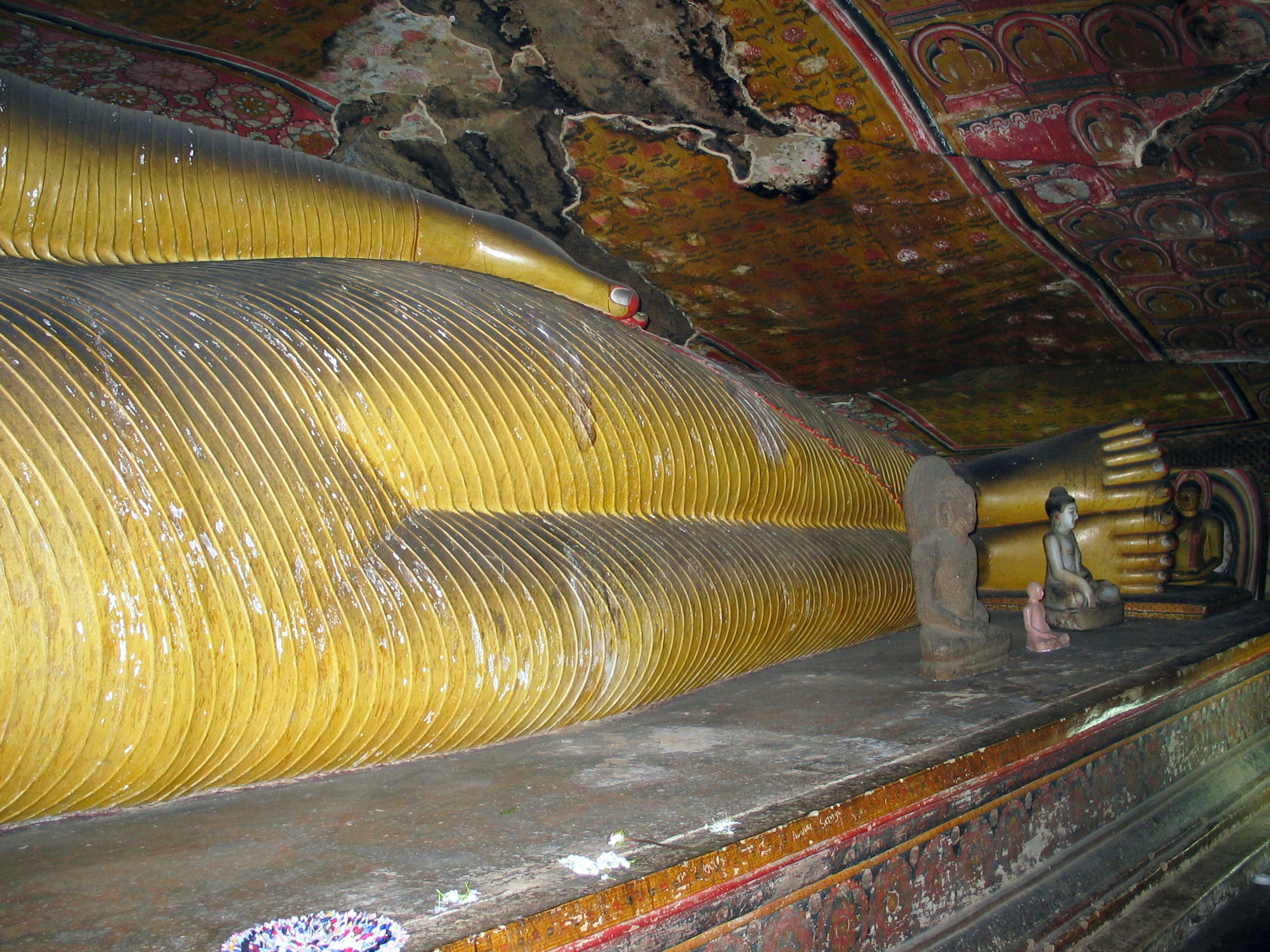 Detailed view of a large golden reclining Buddha with visible ceiling decorations