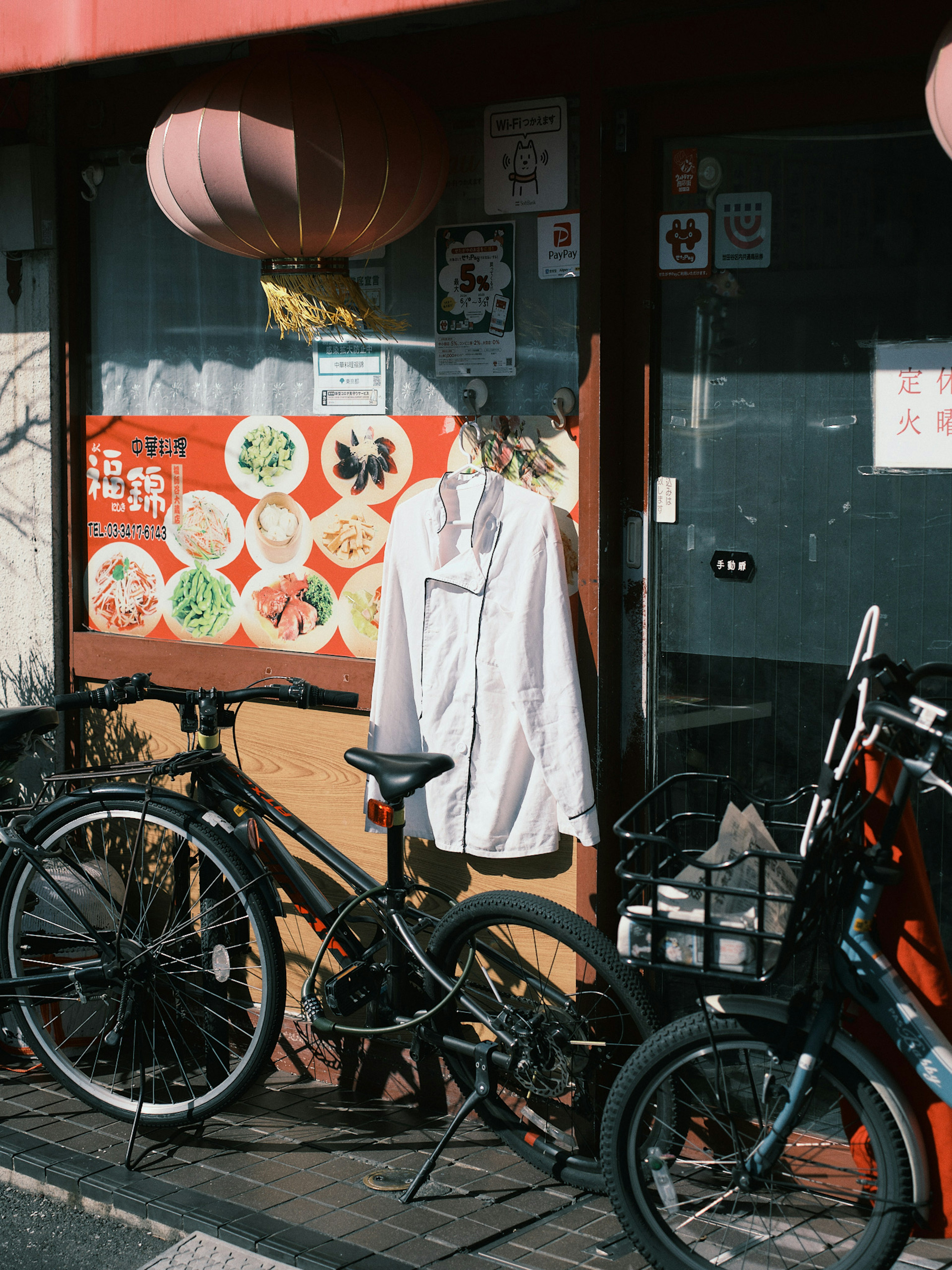 Des vélos et une chemise blanche accrochée à l'entrée d'un magasin